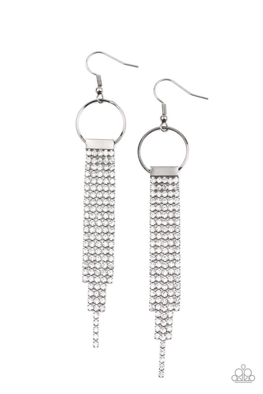 Paparazzi Accessories Tapered Twinkle - White Dainty strands of glittery white rhinestones stream from the bottom of a silver fitting that glides along the bottom of a dainty silver hoop, creating a timelessly tapered fringe. Earring attaches to a standar