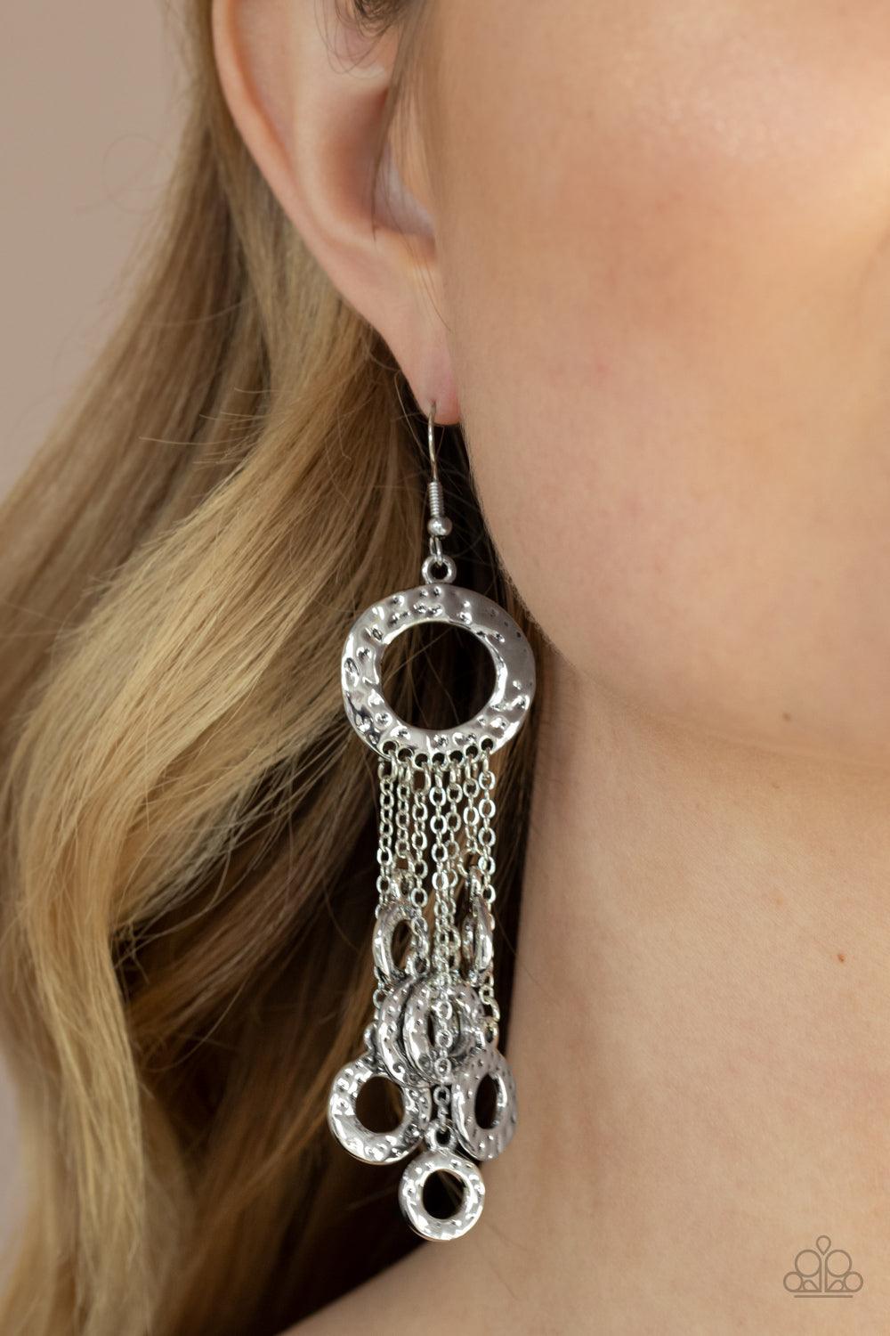Paparazzi Accessories Right Under Your NOISE - Silver Attached to dainty silver chains, a fringe of hammered silver rings swings from the bottom of a matching hammered ring for a noise-making statement. Earring attaches to a standard fishhook fitting. Sol
