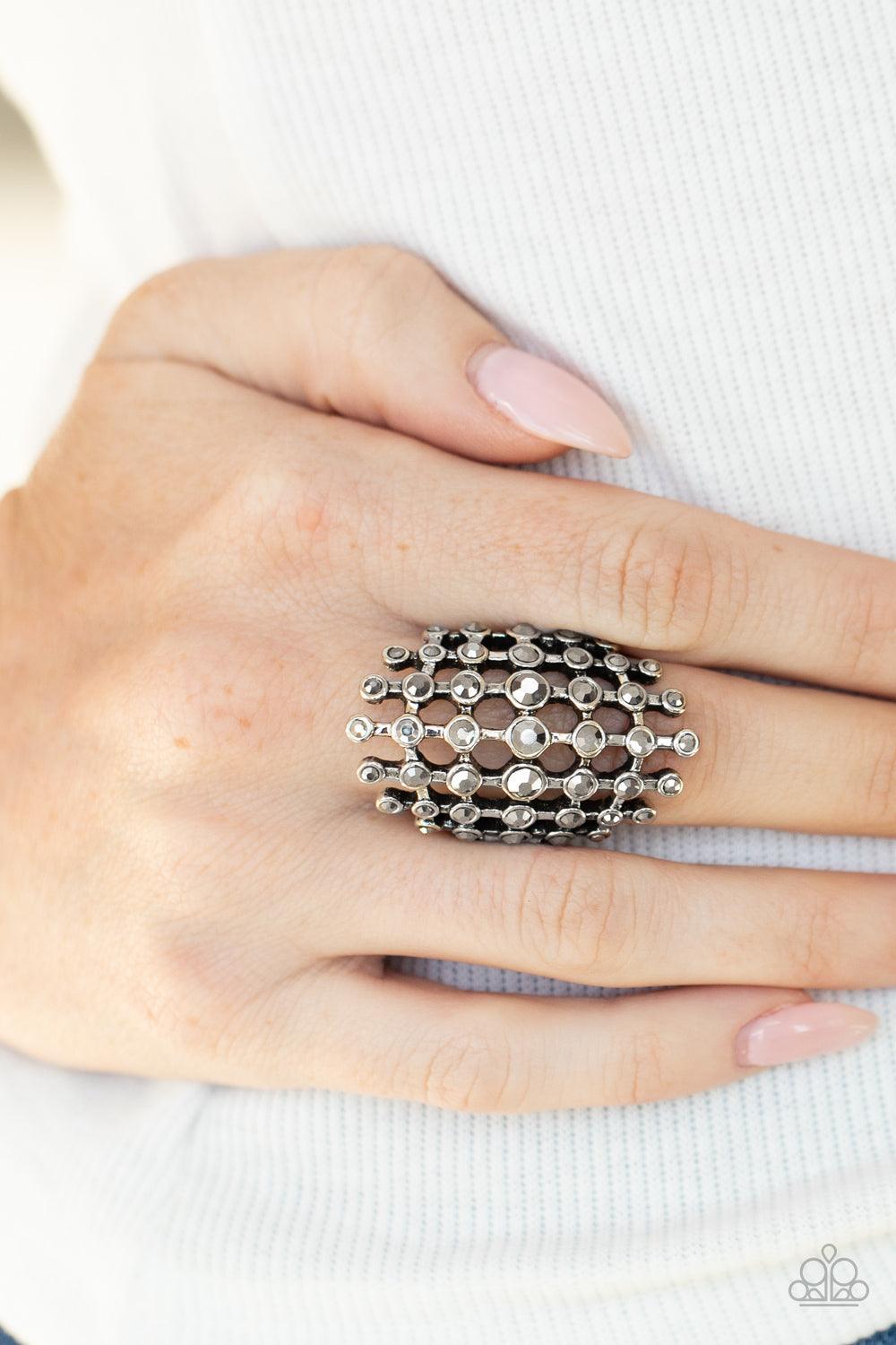 Paparazzi Accessories Fiercely Flashy - Silver Featuring glistening silver fittings, a sparkly series of hematite rhinestones interlock into an edgy grid across the finger for a spellbinding look. Features a stretchy band for a flexible fit. Sold as one i