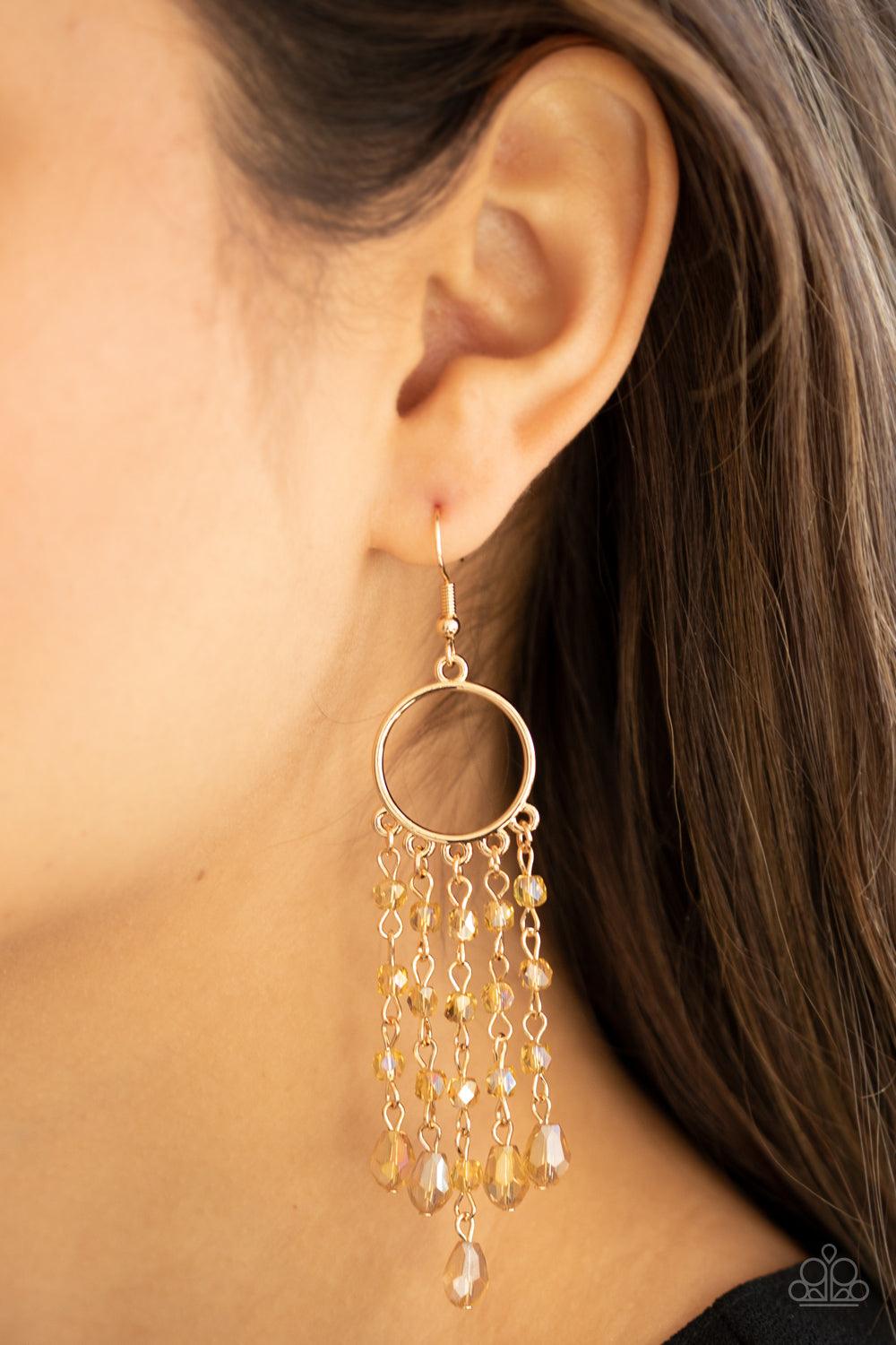 Paparazzi Accessories Dazzling Delicious - Gold Glittery rows of iridescently golden crystal-like beads stream from the bottom of a dainty gold hoop, creating a dazzling chandelier. Earring attaches to a standard fishhook fitting. Sold as one pair of earr