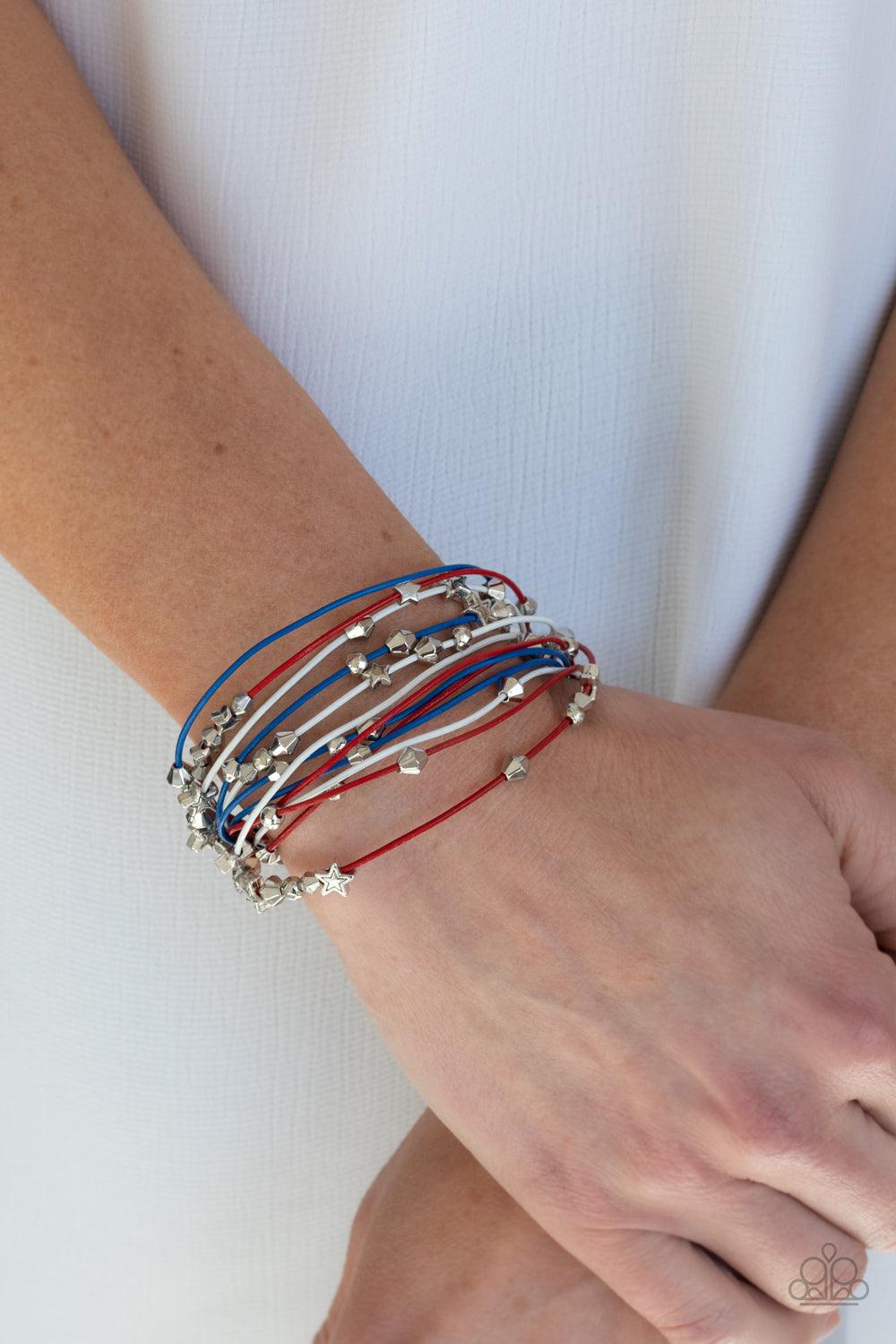 Paparazzi Accessories Star-Studded Affair - Multi A collection of faceted silver beads and silver star charms slides along red, white, and blue cords that layer across the wrist of a colorful look. Features a magnetic closure. Sold as one individual brace
