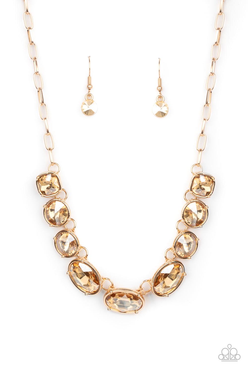 Paparazzi Accessories Gorgeously Glacial - Gold Featuring mismatched round, oval, and square cuts, a golden row of dramatically oversized rhinestones delicately link below the collar for an icy finish. Features an adjustable clasp closure. Sold as one ind