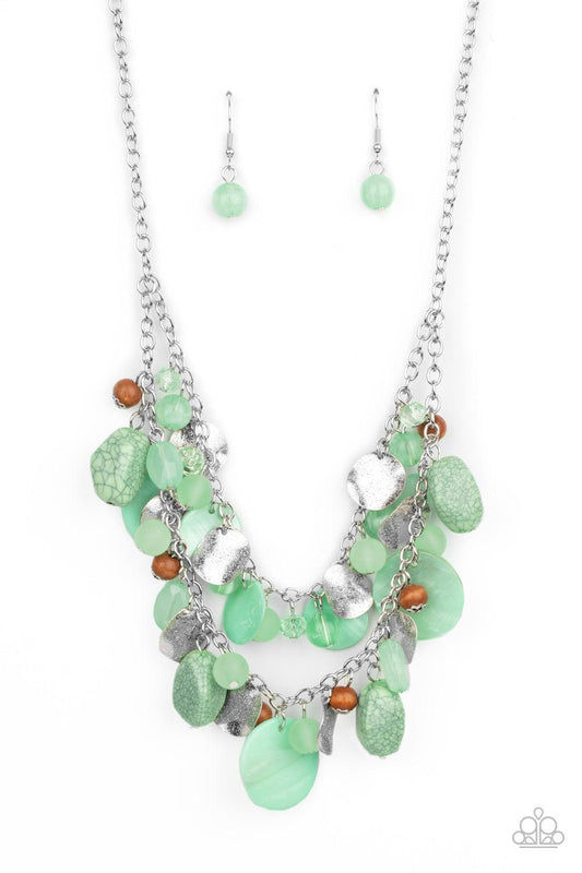 Paparazzi Accessories Spring Goddess - Green Infused with wooden beads and silver discs, an earthy collection of glassy, opaque, and shell-like Green Ash beads swing from two silver chains. The refreshing display effortlessly layers below the collar, crea