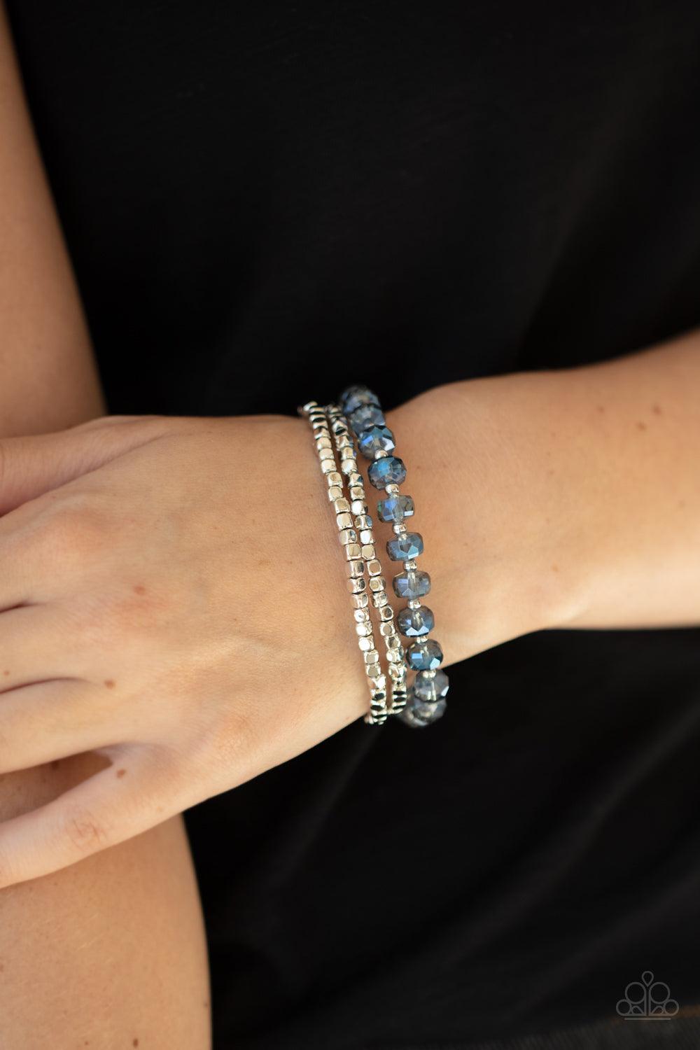 Paparazzi Accessories Celestial Circus - Blue A pair of silver cube beads join one strand of blue crystal-like beads around the wrist, creating iridescently stretchy layers. Sold as one set of three bracelets. Jewelry
