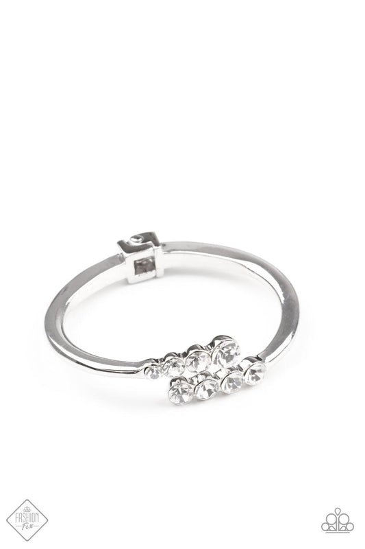Paparazzi Accessories Defying Dazzle - White Attached to two thick silver bars, oversized rows of glittery white rhinestones delicately stack into a hypnotizing centerpiece around the wrist. Features a hinge closure. Sold as one individual bracelet. Jewel