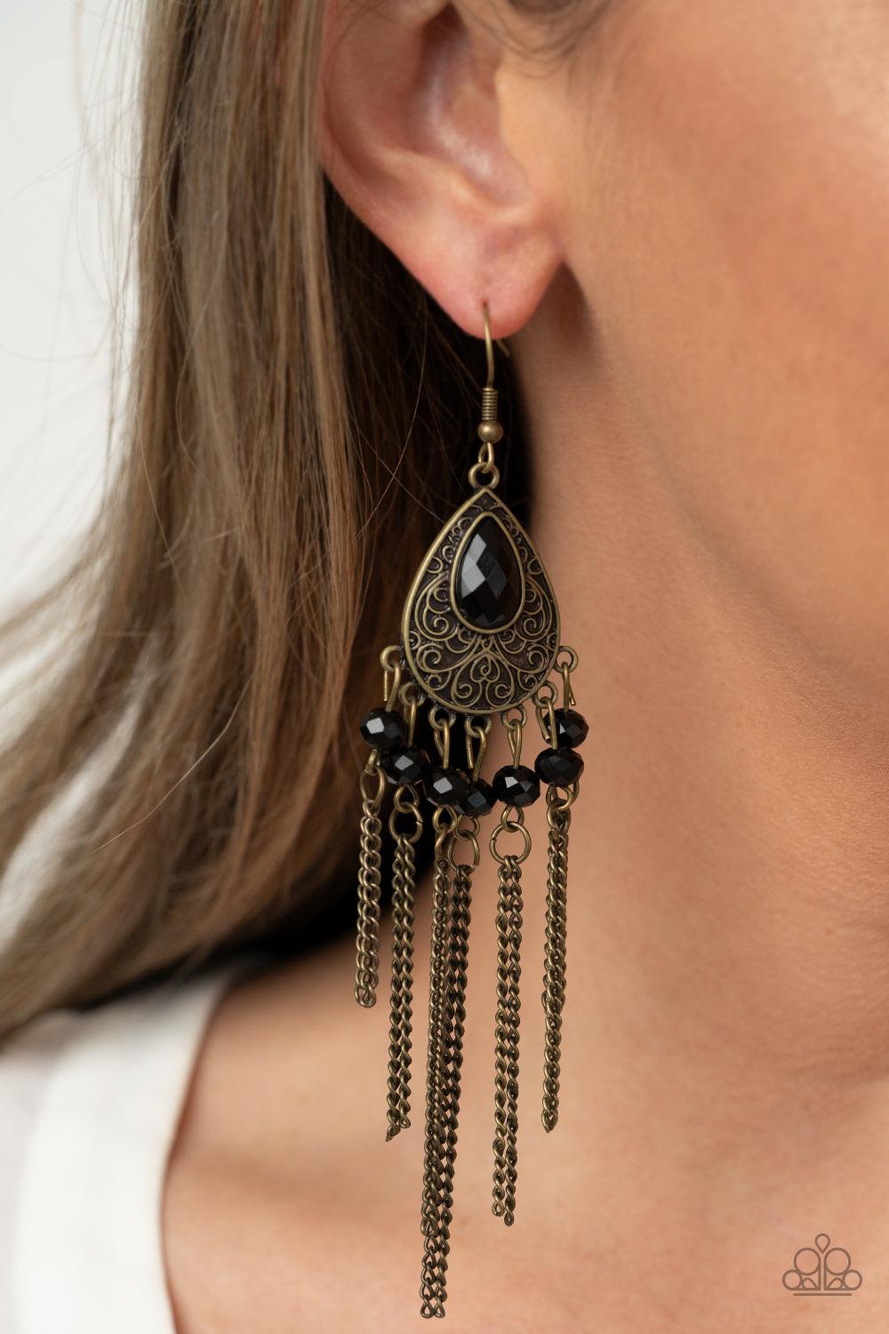 Paparazzi Accessories Floating on HEIR - Brass Dotted with glittery black rhinestones, antiqued brass chains stream from the bottom of a brass filigree embossed teardrop, creating a whimsical fringe. A teardrop black rhinestone dots the frame for a dazzli