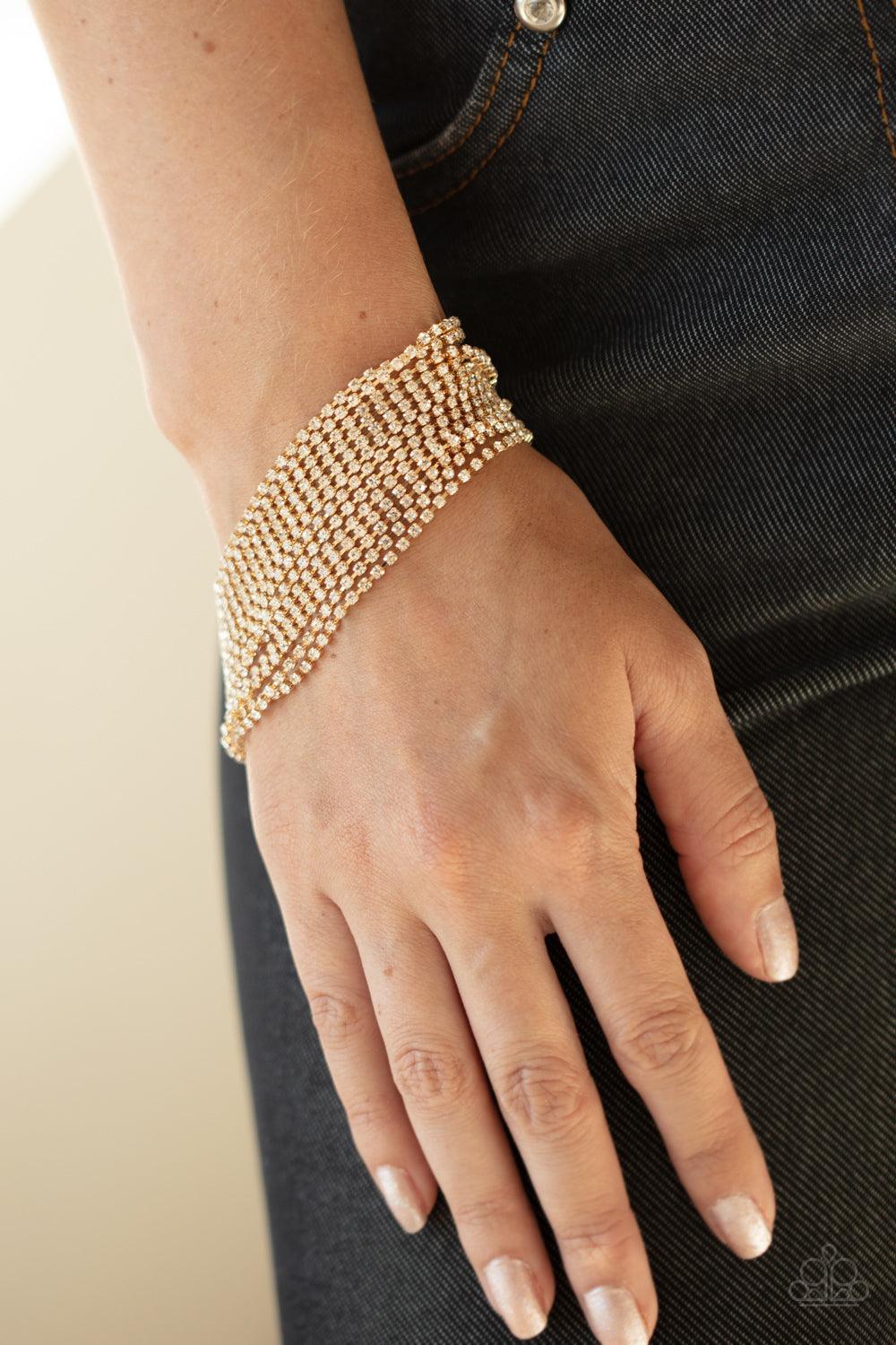 Paparazzi Accessories I Woke Up Like This - Gold Strung between two gold fittings, sparkly strand after sparkly strand of glittery white rhinestones layer around the wrist, creating a glamorous statement piece. Features an adjustable clasp closure. Sold a