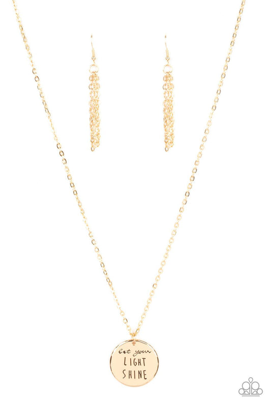 Paparazzi Accessories Light It Up - Gold A glistening gold disc is stamped in the inspiring phrase, "Let your light shine," at the bottom of a shiny gold chain. Features an adjustable clasp closure. Sold as one individual necklace. Includes one pair of ma