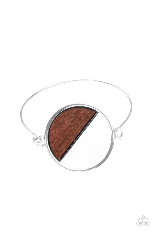 Paparazzi Accessories Timber Trade - Brown Attached to a dainty silver bar that curls around the wrist, a crescent shaped wooden accent adorns half of an airy circular centerpiece for a modern twist. Features a toggle closure. Sold as one individual brace