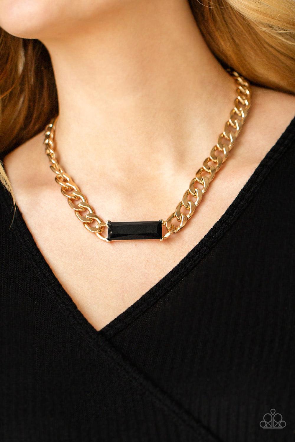 Paparazzi Accessories Urban Royalty - Gold A dramatically oversized row of gold chain attaches to a black emerald cut rhinestone pendant, creating a demanding centerpiece below the collar. Features an adjustable clasp closure. Sold as one individual neckl