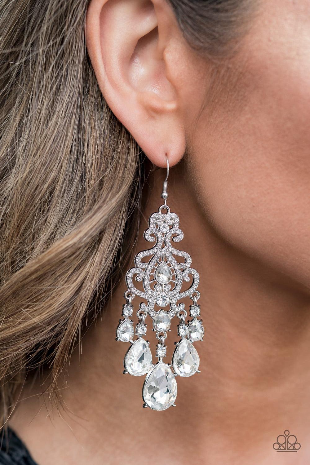 Paparazzi Accessories Queen Of All Things Sparkly - White Gradually increasing in size, glassy white teardrop gems create a dramatic fringe at the bottom of a decorative silver frame swirling with dainty white rhinestones for a timelessly over-the-top spa