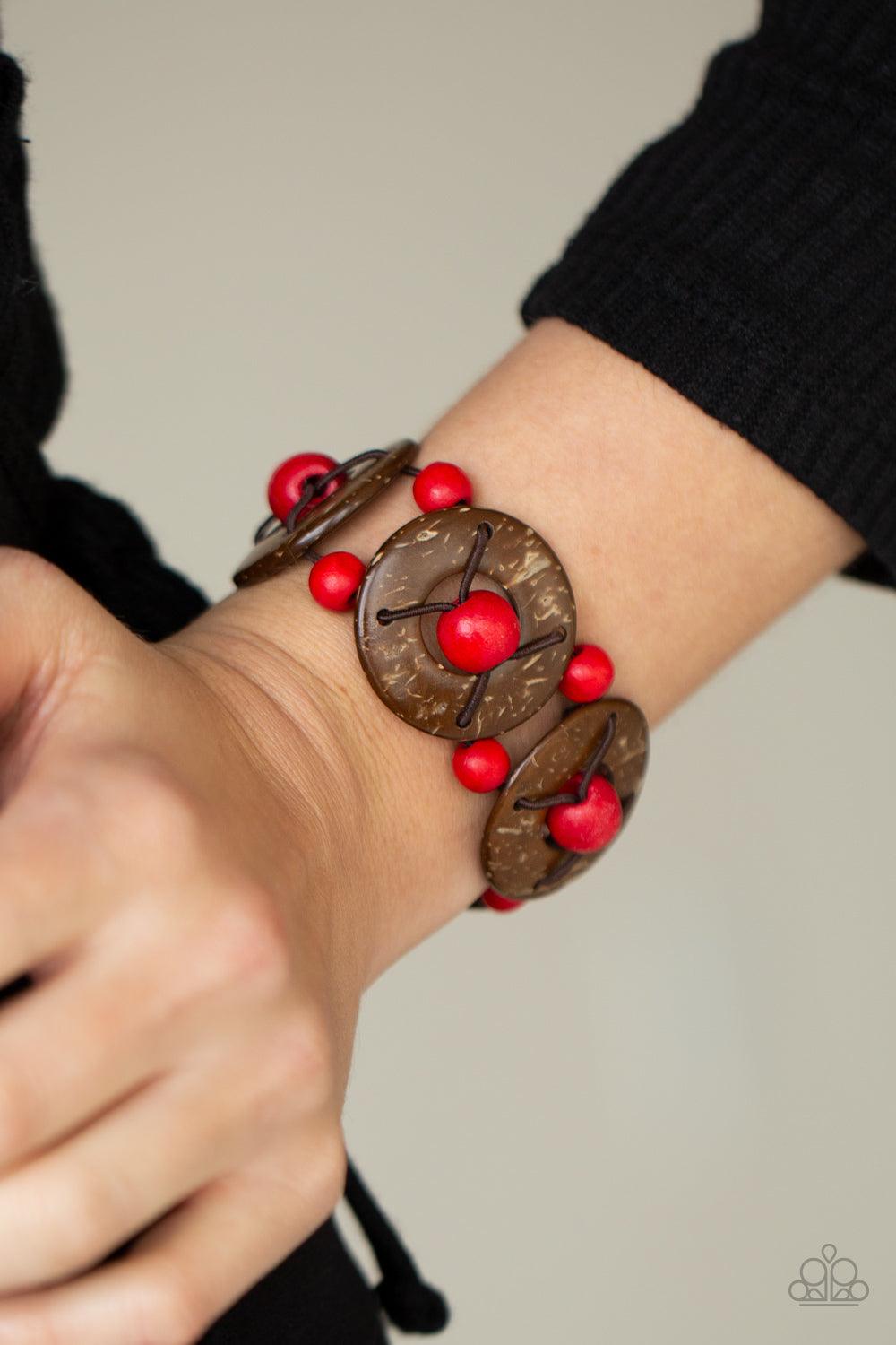 Paparazzi Accessories Island Adventure - Red An oversized collection of red wooden beads and distressed brown wooden discs are threaded along stretchy bands that decoratively weave around the wrist for a summery flair. Sold as one individual bracelet. Jew