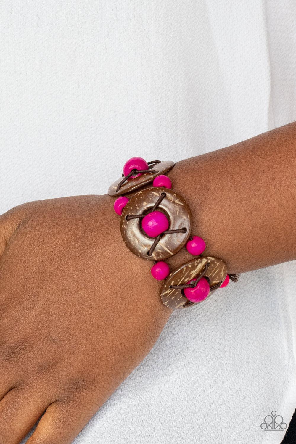 Paparazzi Accessories Island Adventure - Pink An oversized collection of pink wooden beads and distressed brown wooden discs are threaded along stretchy bands that decoratively weave around the wrist for a summery flair. Sold as one individual bracelet. J