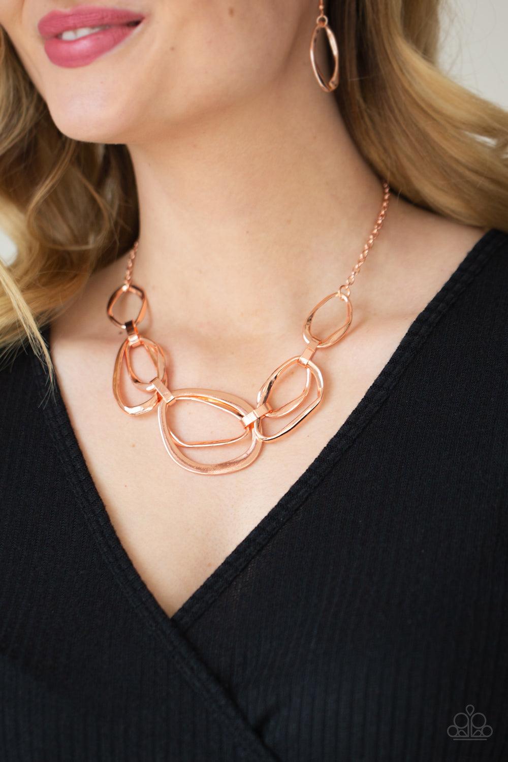 Paparazzi Accessories Prehistoric Heirloom - Copper An asymmetrical assortment of twisted and flattened shiny copper rings delicately link below the collar with oversized shiny copper fittings, creating an intense industrial display below the collar. Feat