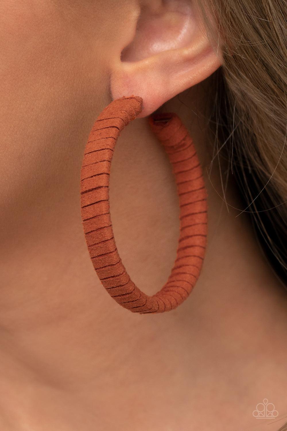 Paparazzi Accessories Suede Parade - Orange Orange suede cording wraps around an oversized hoop, creating an earthy pop of color. Earring attaches to a standard post fitting. Hoop measures approximately 2 1/4" in diameter. Sold as one pair of hoop earring