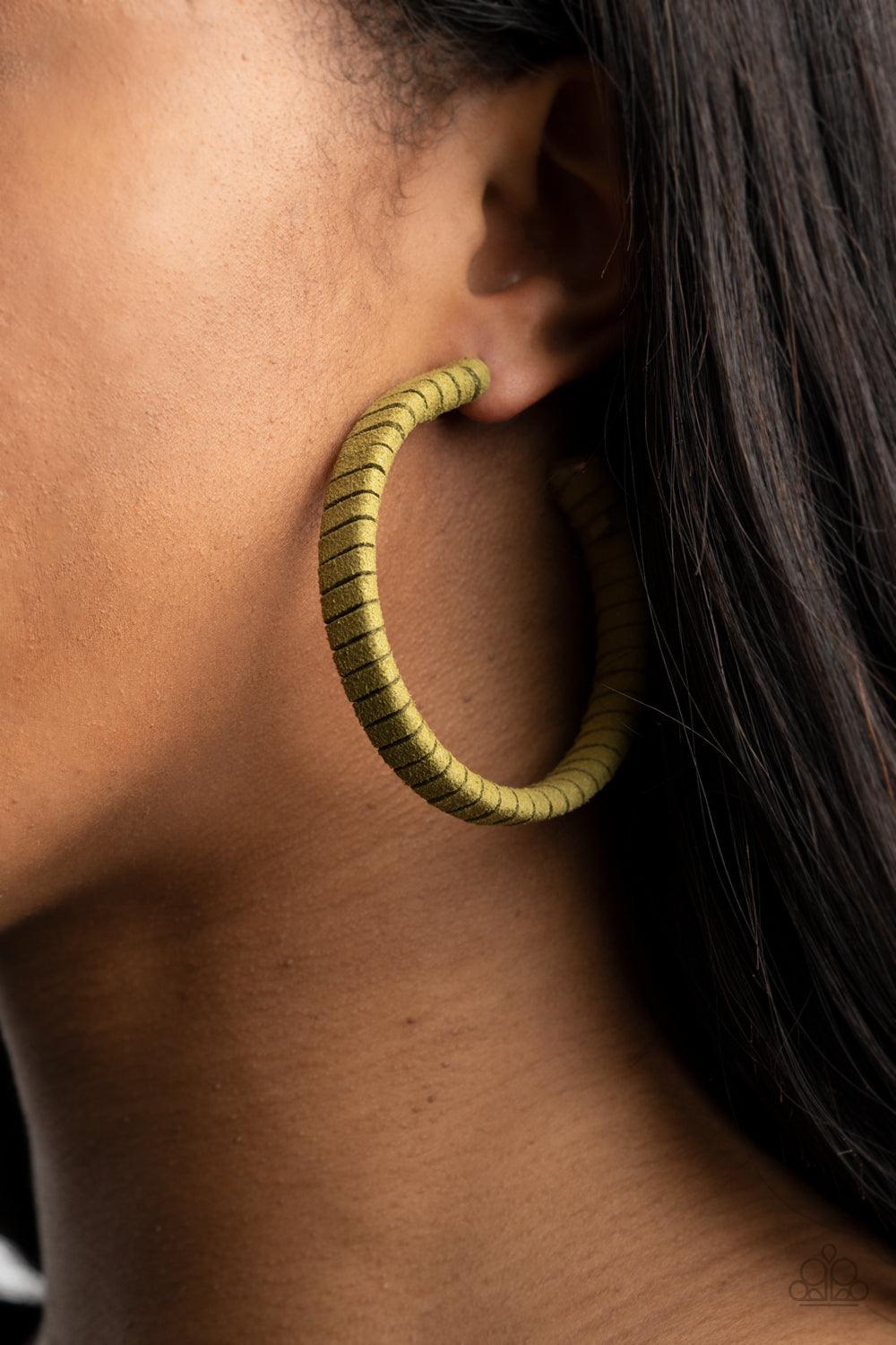 Paparazzi Accessories Suede Parade - Green Green suede cording wraps around an oversized hoop, creating an earthy pop of color. Earring attaches to a standard post fitting. Hoop measures approximately 2 1/4" in diameter. Sold as one pair of hoop earrings.