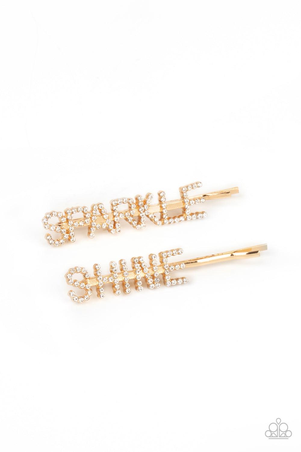 Paparazzi Accessories Center of the SPARKLE-verse - Gold Glassy white rhinestones spell out "Sparkle," and "Shine," across the fronts of two gold bobby pins, creating a sparkly duo. Sold as one pair of decorative bobby pins. Hair Claws & Clips