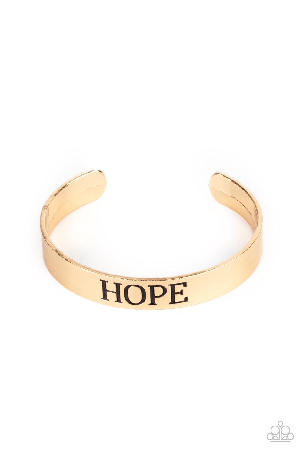 Paparazzi Accessories Hope Makes The World Go Round - Gold The center of a shiny gold cuff is stamped in the word, "Hope," for an inspirational look. Sold as one individual bracelet. Jewelry