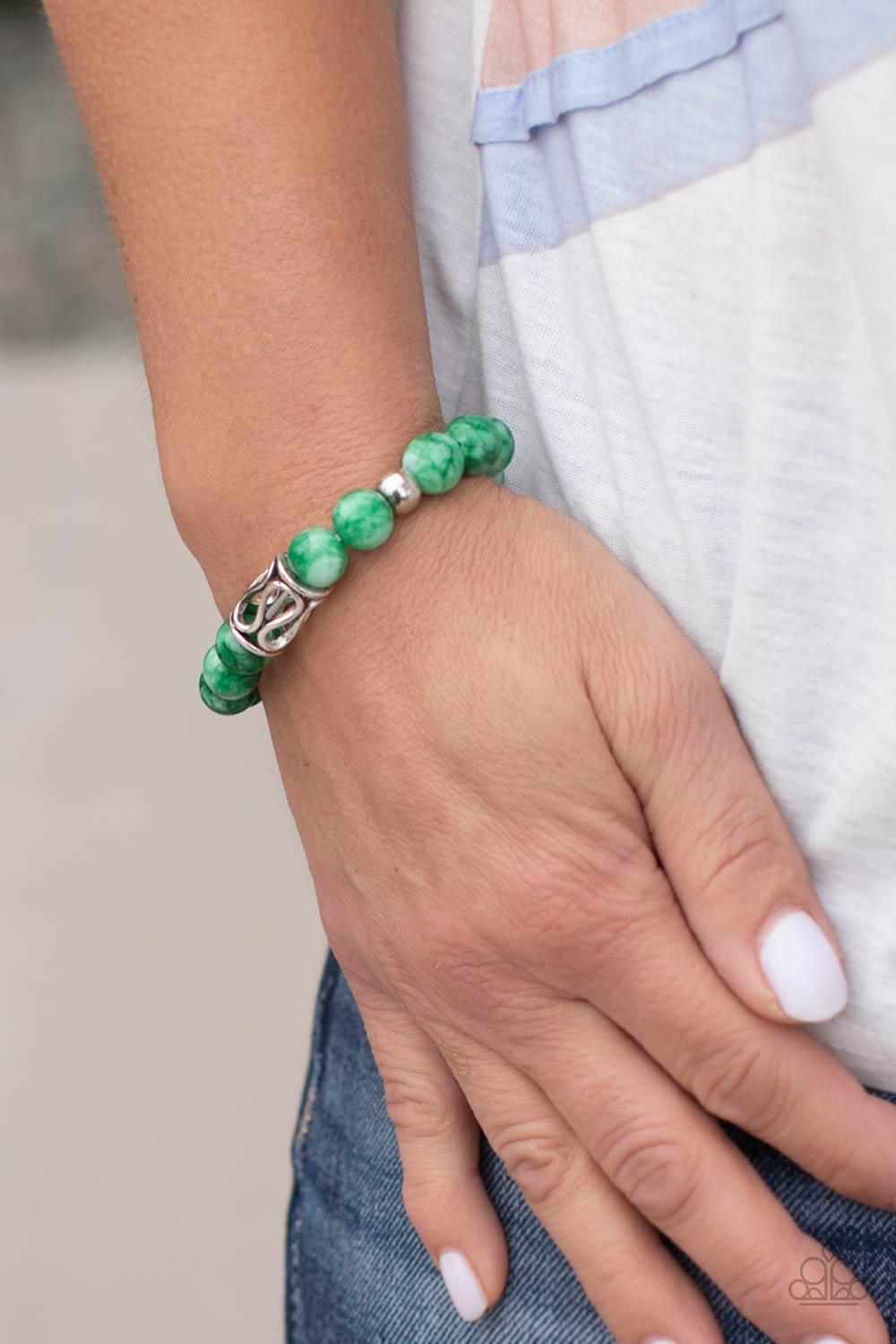 Paparazzi Accessories Soothes The Soul - Green Infused with an ornate silver centerpiece, an earthy collection of silver and jade beads are threaded along a stretchy band around the wrist for a seasonal flair. Sold as one individual bracelet. Bracelets