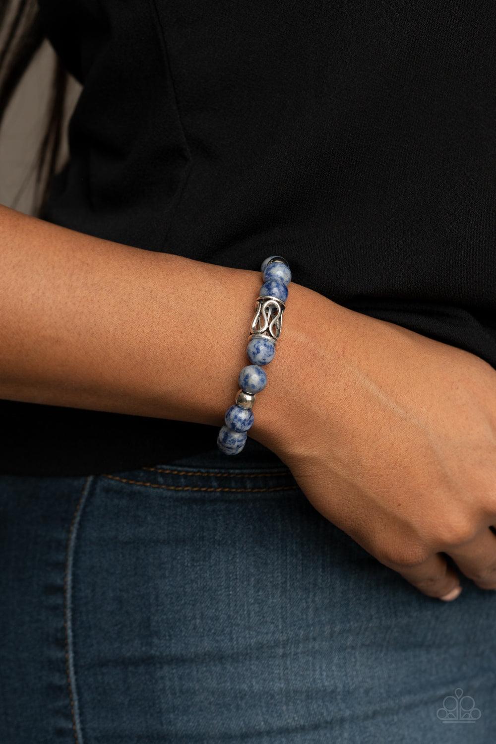 Paparazzi Accessories Soothes The Soul - Blue Infused with an ornate silver centerpiece, an earthy collection of silver and lapis lazuli beads are threaded along a stretchy band around the wrist for a seasonal flair. Sold as one individual bracelet. Jewel