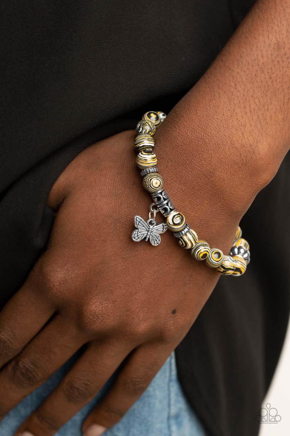 Paparazzi Accessories Butterfly Wishes - Yellow Swirling with yellow, black, and white accents, colorful stone beads and ornate silver accents are threaded along stretchy bands around the wrist. A dainty silver butterfly charm dangles from the display, ad