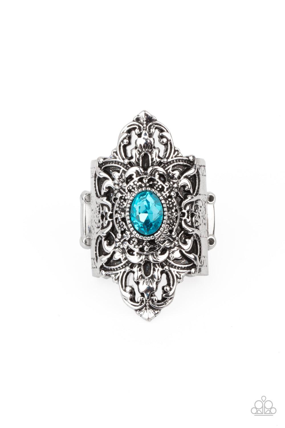 Paparazzi Accessories Perennial Posh - Blue A glittery blue rhinestone adorns the center of a scalloped silver frame that is embossed in a rustic floral backdrop, creating a leafy centerpiece atop the finger. Features a stretchy band for a flexible fit. S