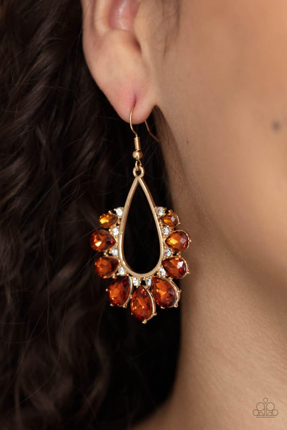 Paparazzi Accessories Two Can Play That Game - Brown Gradually increasing in size, a glittery collection of topaz teardrop rhinestones fan out from a white rhinestone dotted gold teardrop frame, creating a sparkly statement. Earring attaches to a standard