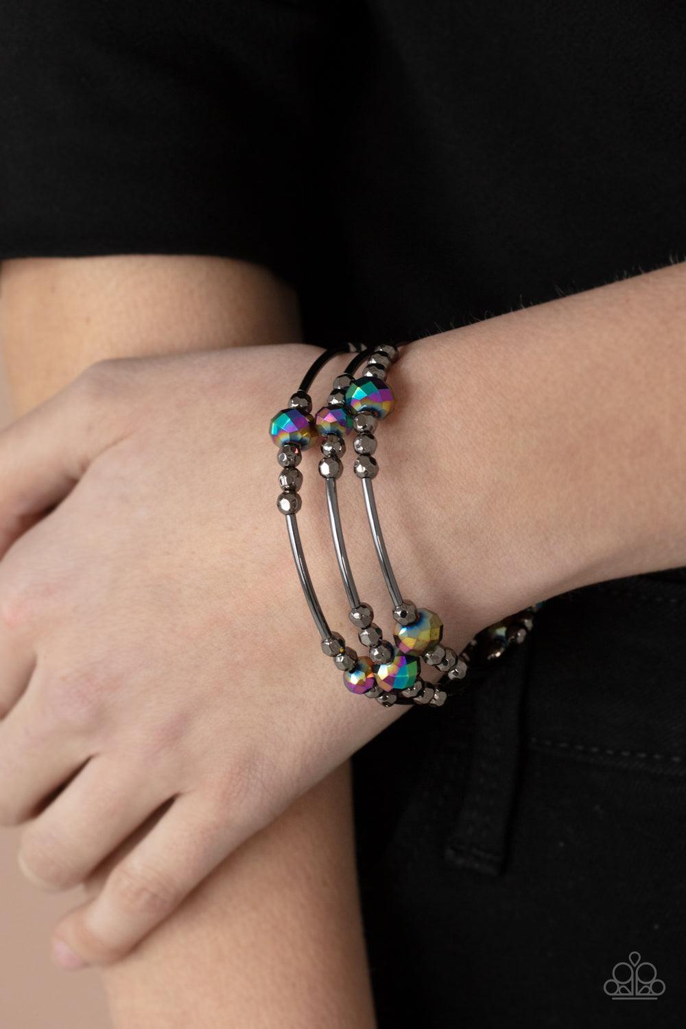 Paparazzi Accessories Showy Shimmer - Multi A shimmery collection of dainty gunmetal beads, oil spill crystal-like accents, and gunmetal rods are threaded along a coiled wire around the wrist, creating a stellar infinity wrap bracelet. Sold as one individ