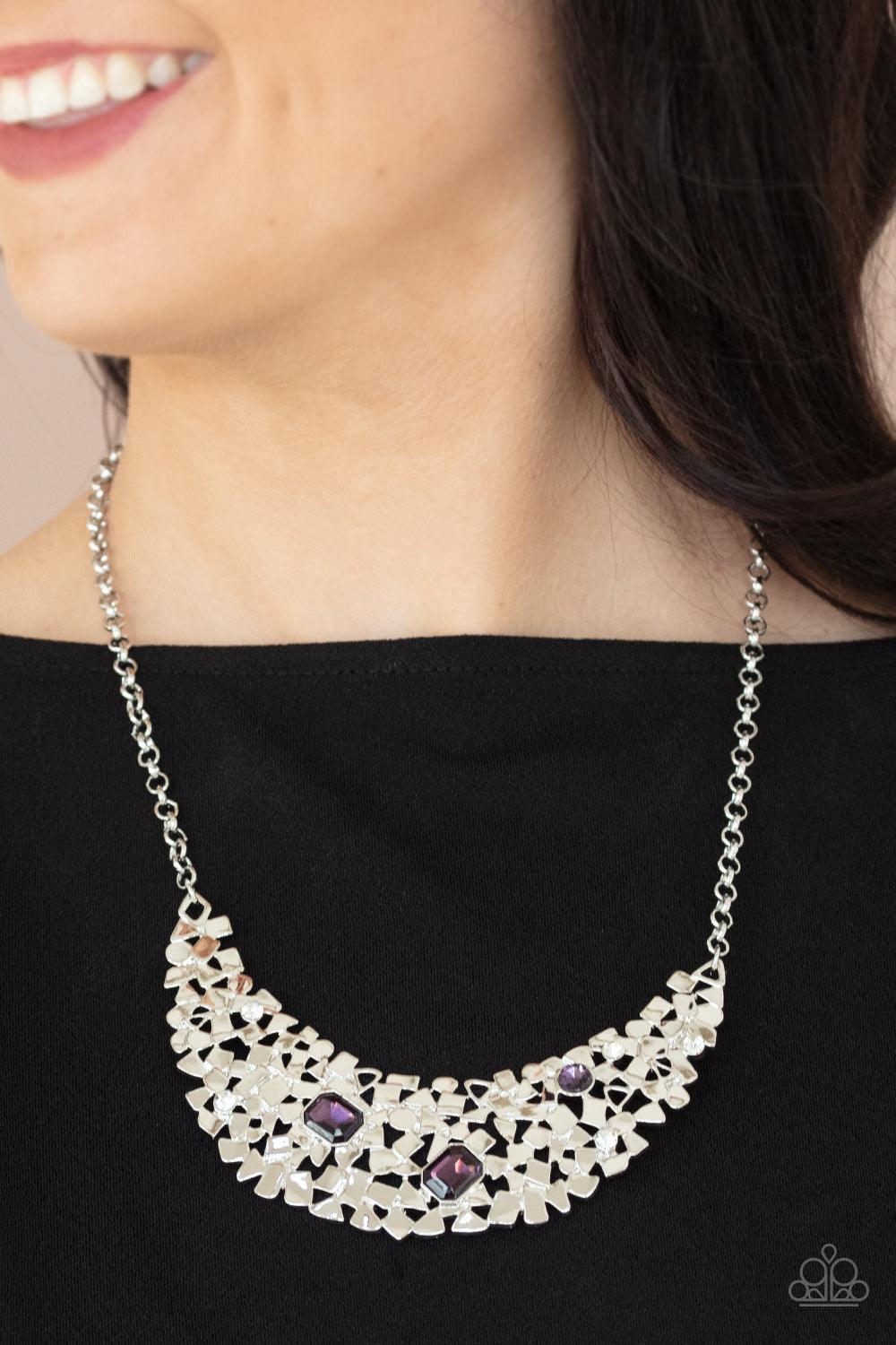 Paparazzi Accessories Fabulously Fragmented - Purple Sporadically dotted in mismatched purple and white rhinestones, a smattering of fragmented silver frames coalesce into a bold half moon below the collar for an edgy fashion. Features an adjustable clasp