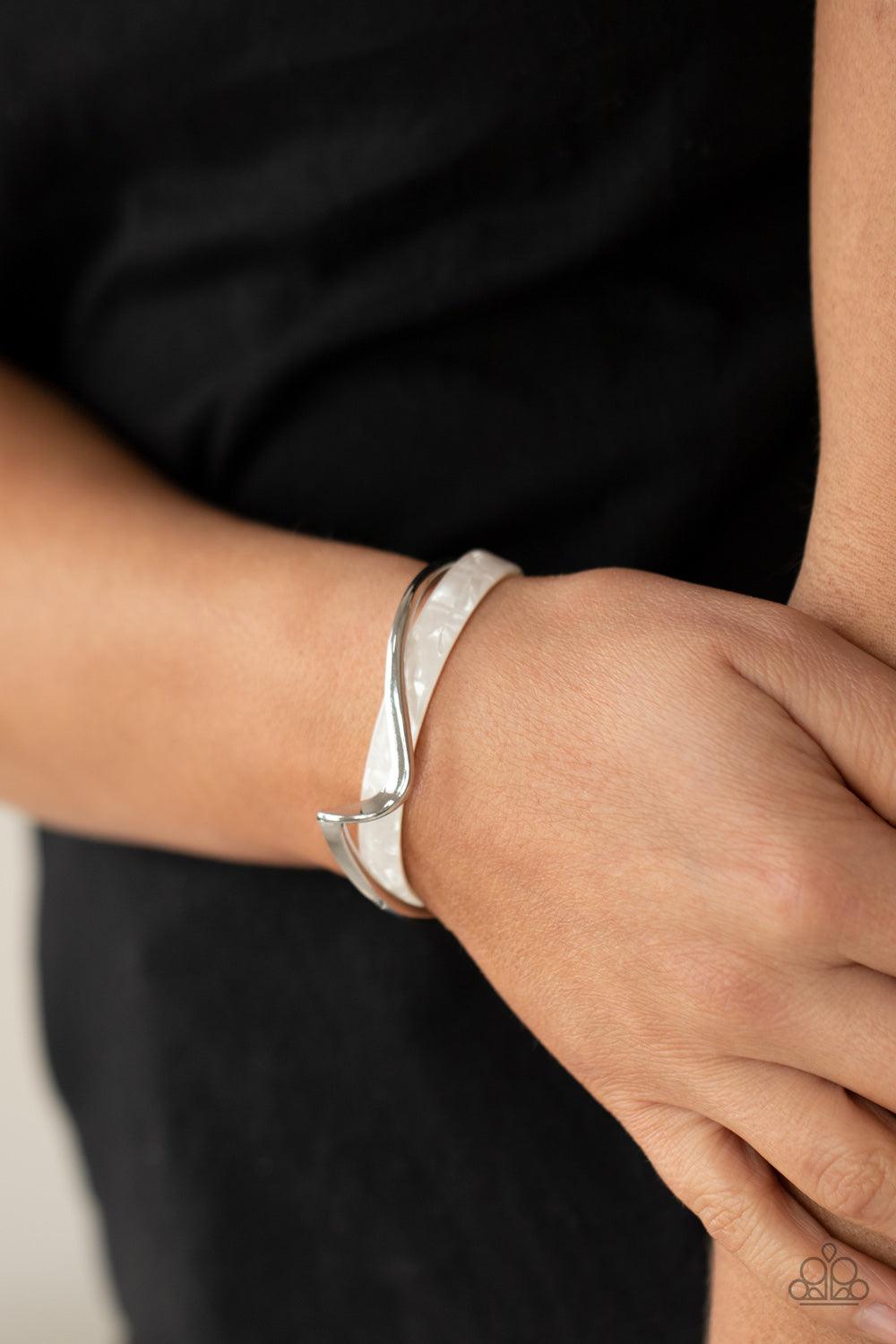 Paparazzi Accessories Craveable Curves - White A flat silver bar delicately curls across a dainty white shell-like acrylic cuff, creating a whimsical centerpiece around the wrist. Sold as one individual bracelet. Jewelry