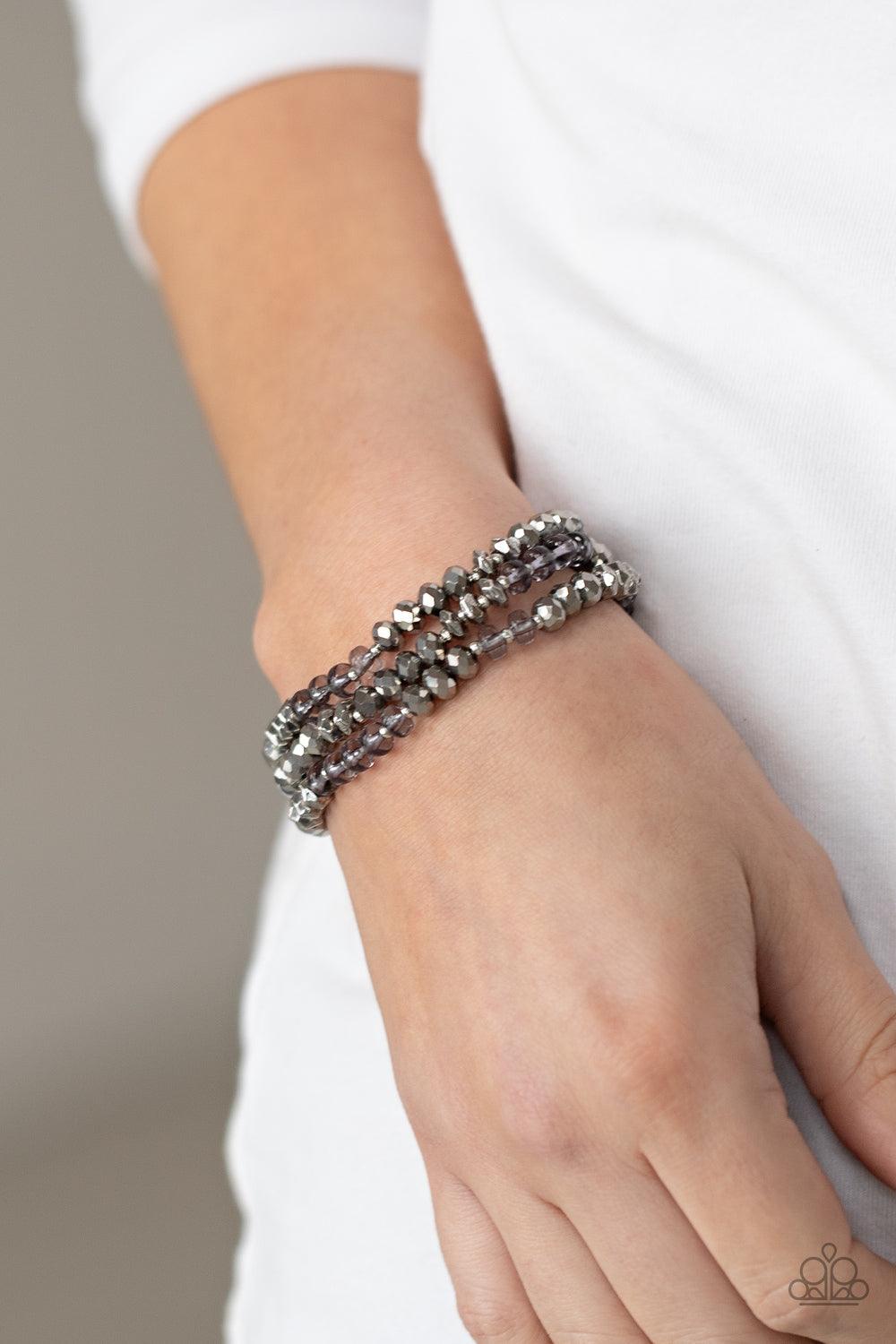 Paparazzi Accessories Stellar Strut - Silver Infused with faceted silver beads, a glamorous collection of sparkly hematite crystals and smoky beads are threaded along stretchy bands around the wrist, creating glittery layers. Sold as one set of three brac