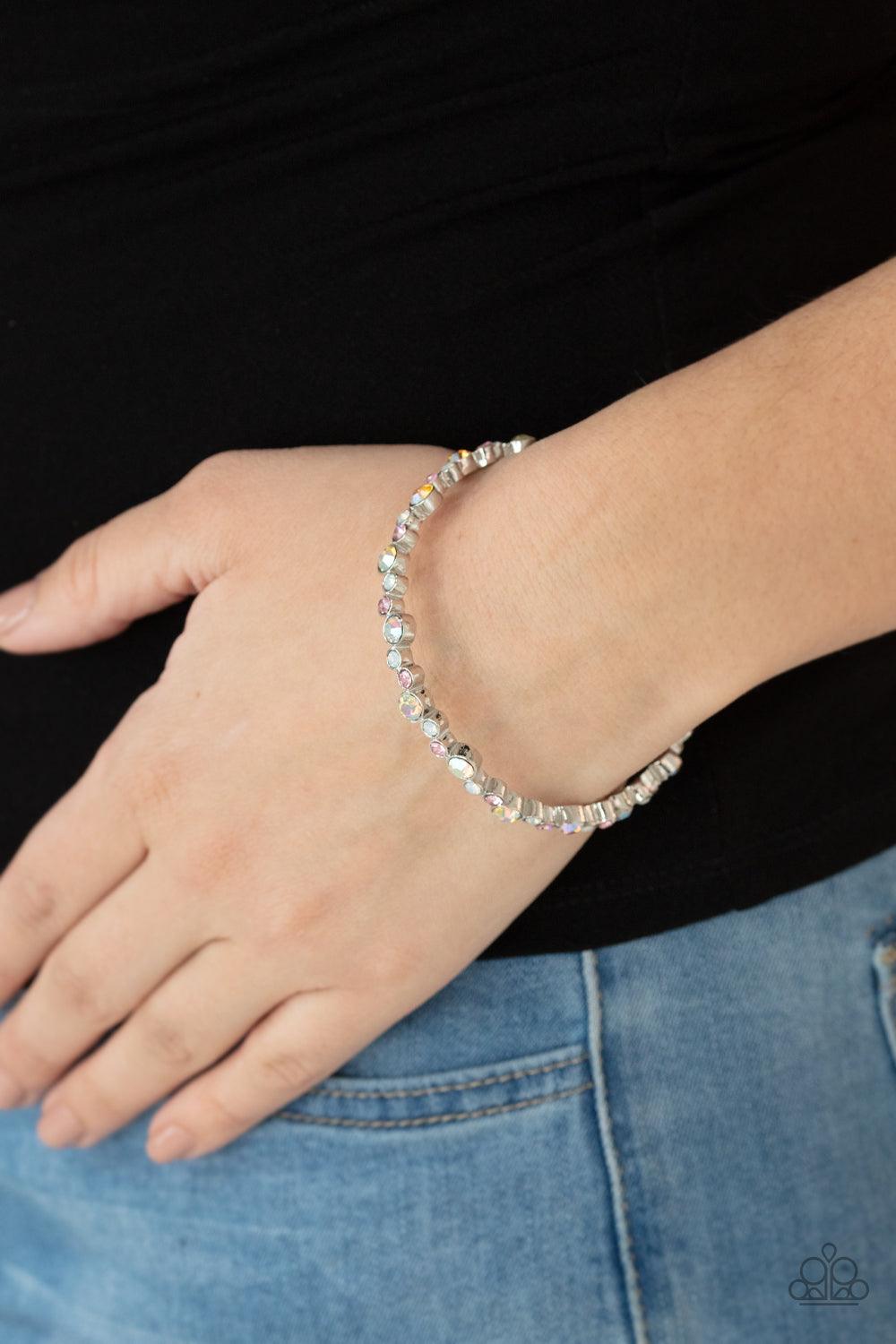 Paparazzi Accessories Twinkly Trendsetter - Multi Encased in sleek silver fittings, a twinkly collection of dark pink, iridescent, and white rhinestones coalesce into a glittery bangle around the wrist. Sold as one individual bracelet. Jewelry