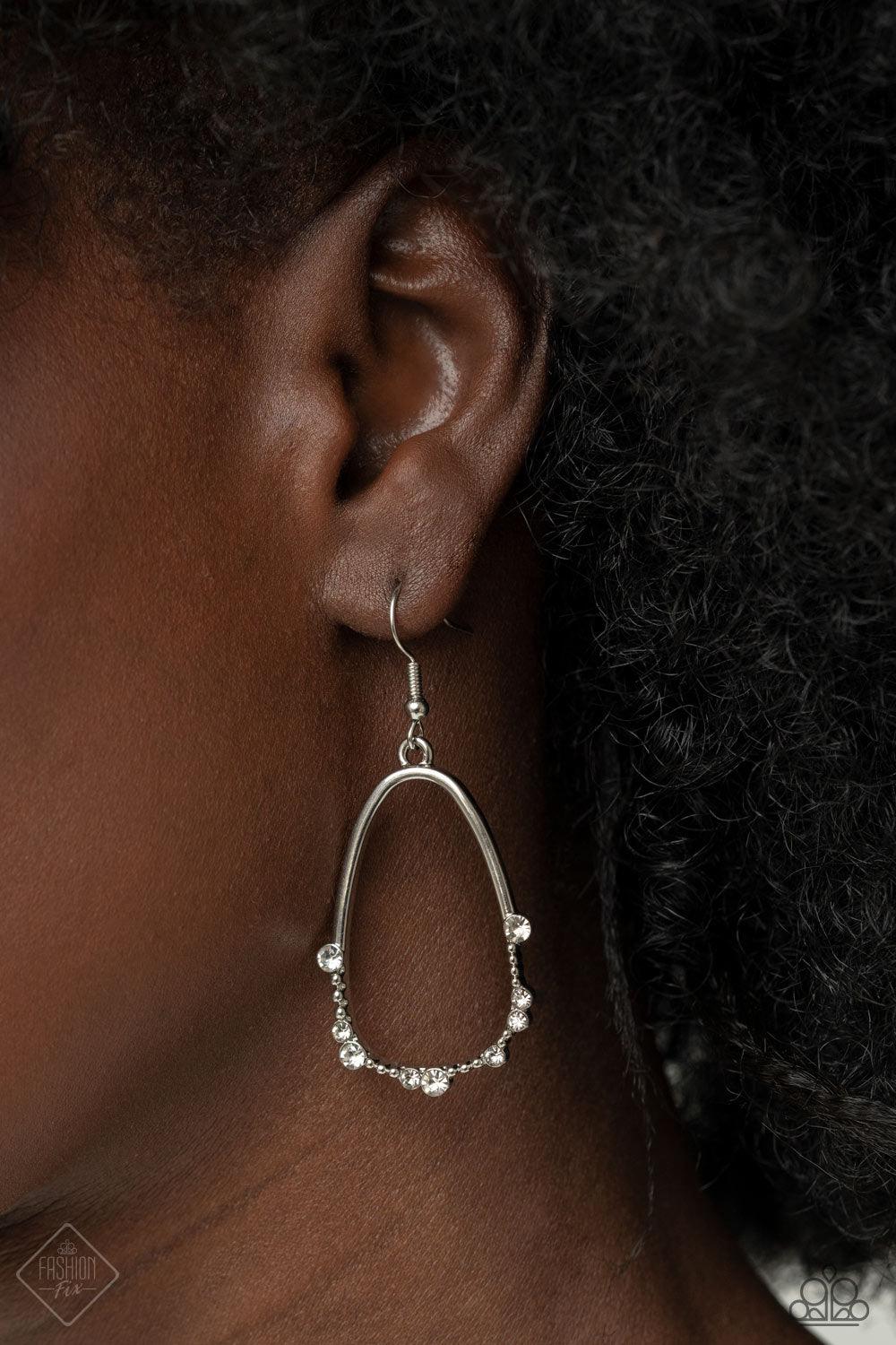 Paparazzi Accessories Ready or YACHT - White The bottom edge of an airy asymmetrical silver teardrop frame is studded and dotted in dainty white rhinestones, creating an elegant display. Earring attaches to a standard fishhook fitting. Sold as one pair of