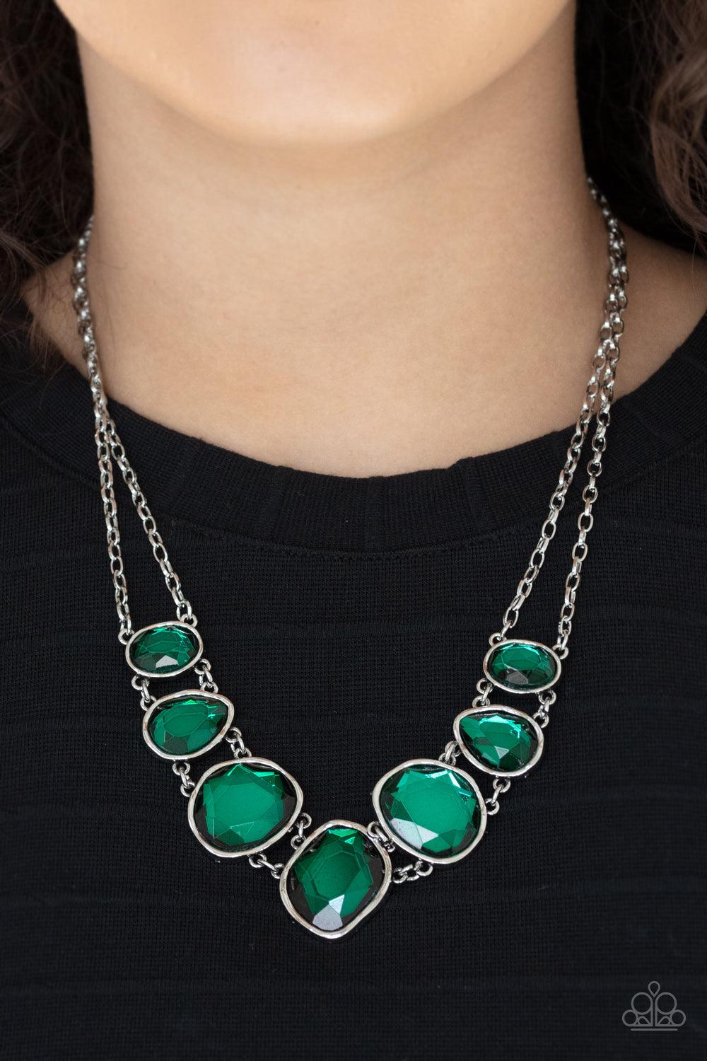 Paparazzi Accessories Absolute Admiration - Green Encased in hammered asymmetrical silver frames, an imperfect collection of faceted green gems are suspended from two shimmery silver chains as they double-link below the collar for a dramatic effect. Featu