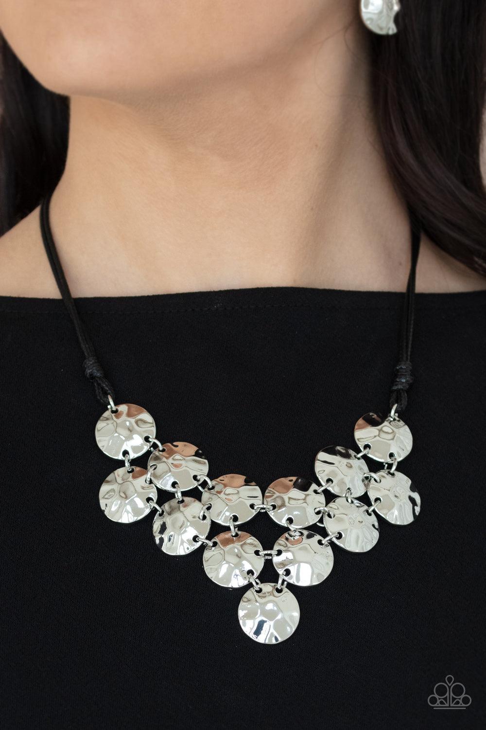 Paparazzi Accessories Token Treasure - Black Featuring a hammered finish, a collection of shiny silver discs delicately connect into a netted pendant at the bottom of knotted black cords for a statement-making look. Features an adjustable clasp closure. S