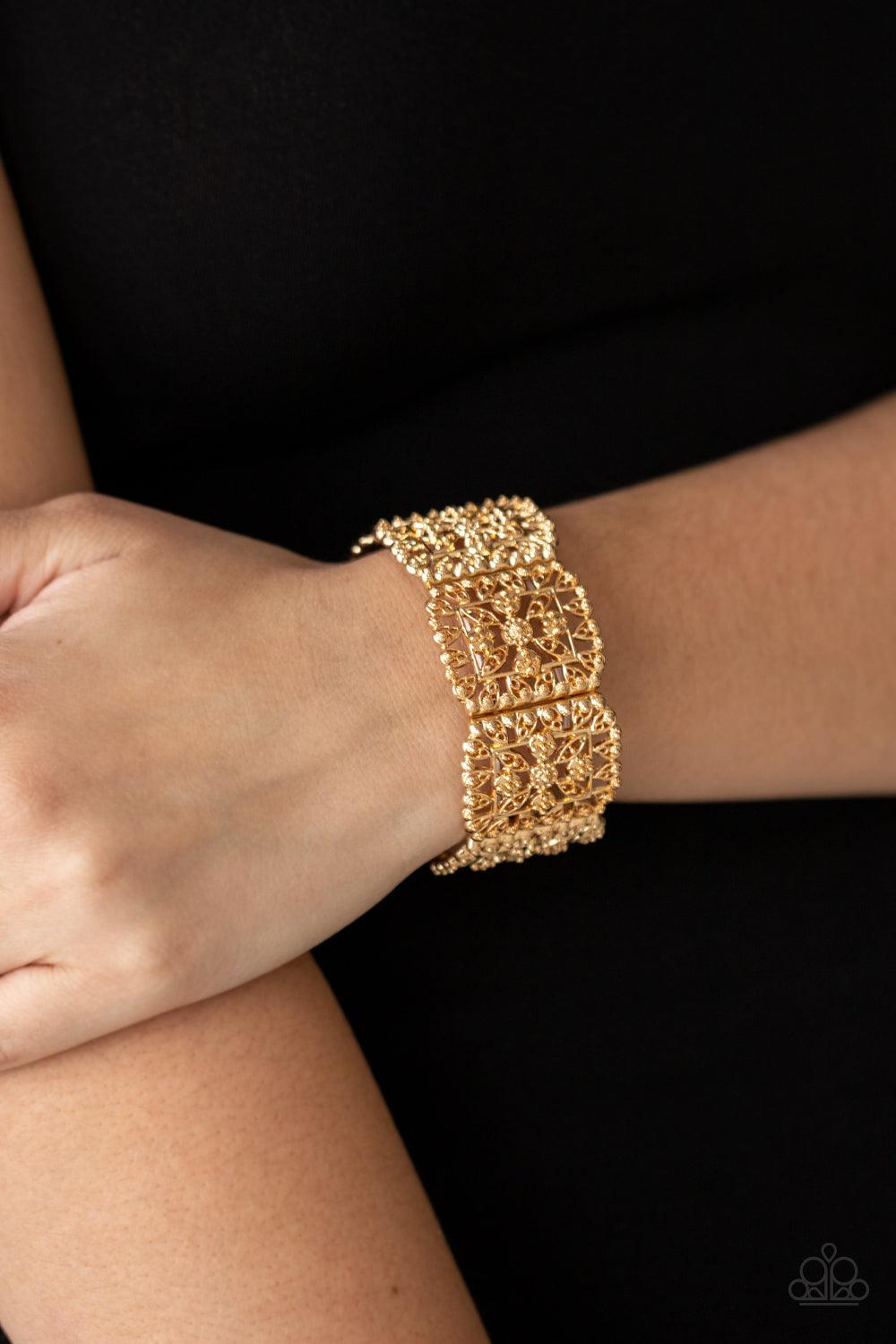 Paparazzi Accessories Enchanted Vineyards - Gold Ornately studded leafy filigree delicately gathers into airy gold square frames that are threaded along stretchy bands around the wrist, creating a vintage inspired look. Sold as one individual bracelet. Je