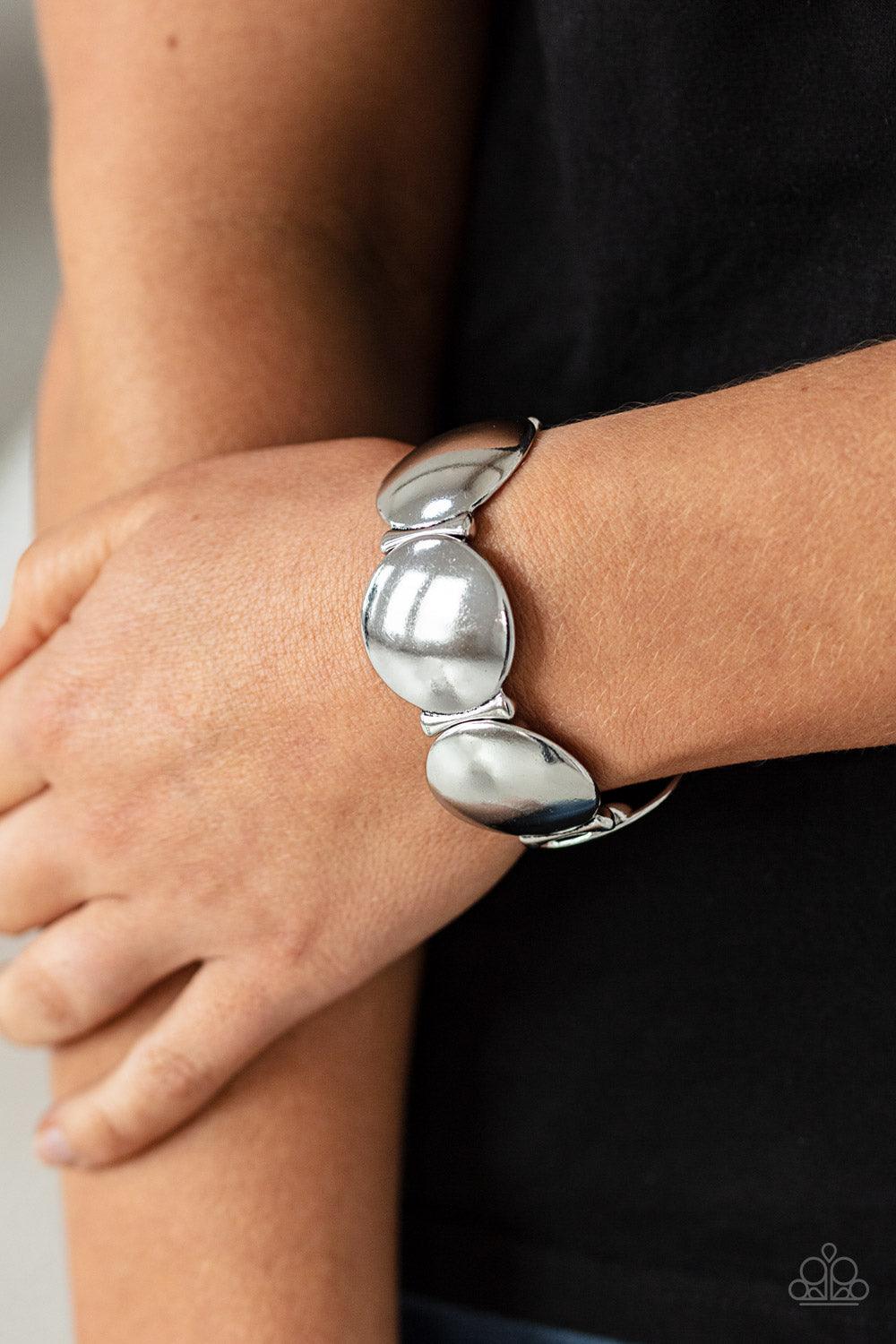 Paparazzi Accessories Going, Going, GONG! - Silver Infused with curved bar-like accents, a shiny series of beveled silver discs are threaded along stretchy bands around the wrist for a bubbly metallic look. Sold as one individual bracelet. Jewelry