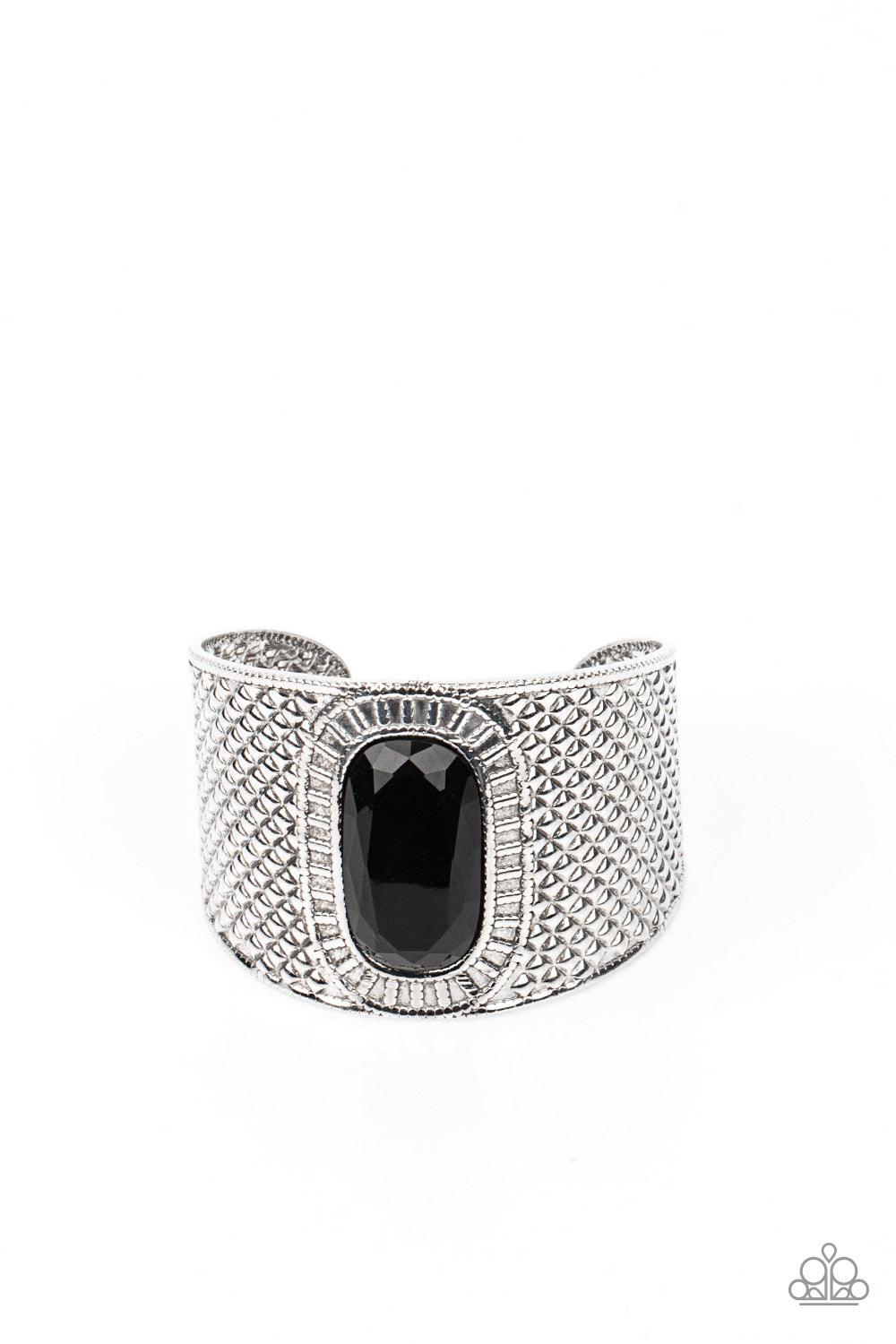 Paparazzi Accessories Poshly Pharaoh - Black An ovsized black gem is pressed into the center of a thick silver cuff embossed in diamond-like textures, creating a bold tribal inspired centerpiece around the wrist. Sold as one individual bracelet. Jewelry