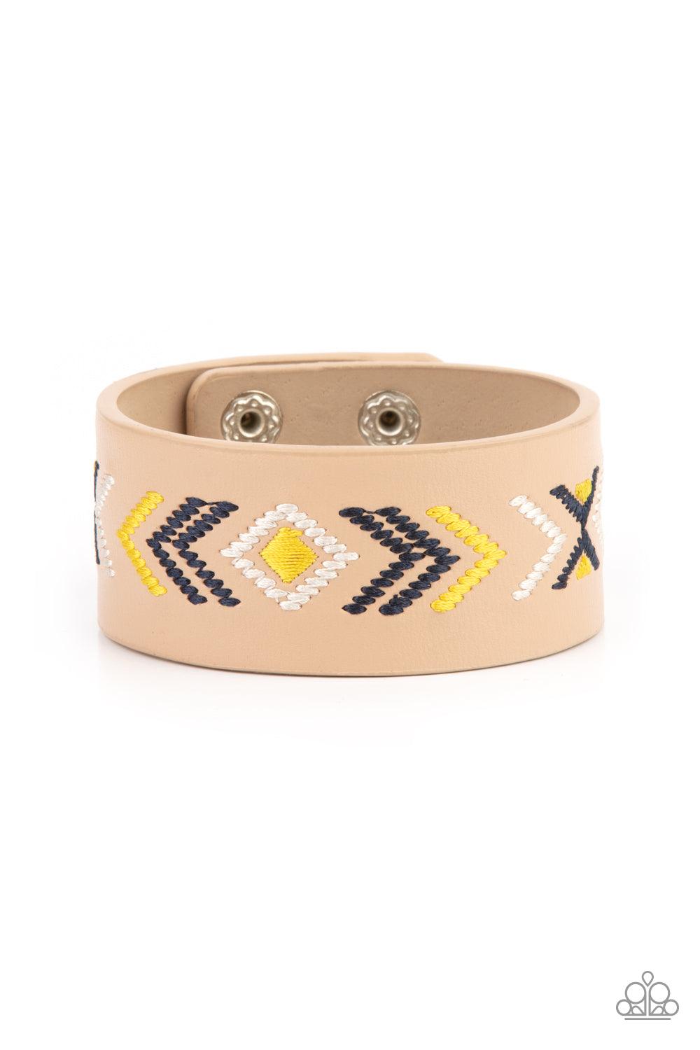 Paparazzi Accessories Cliff Glyphs - Yellow Yellow, blue, and white thread is stitched across the front of a brown leather band, creating a colorful tribal inspired pattern. Features an adjustable snap closure. Sold as one individual bracelet. Jewelry