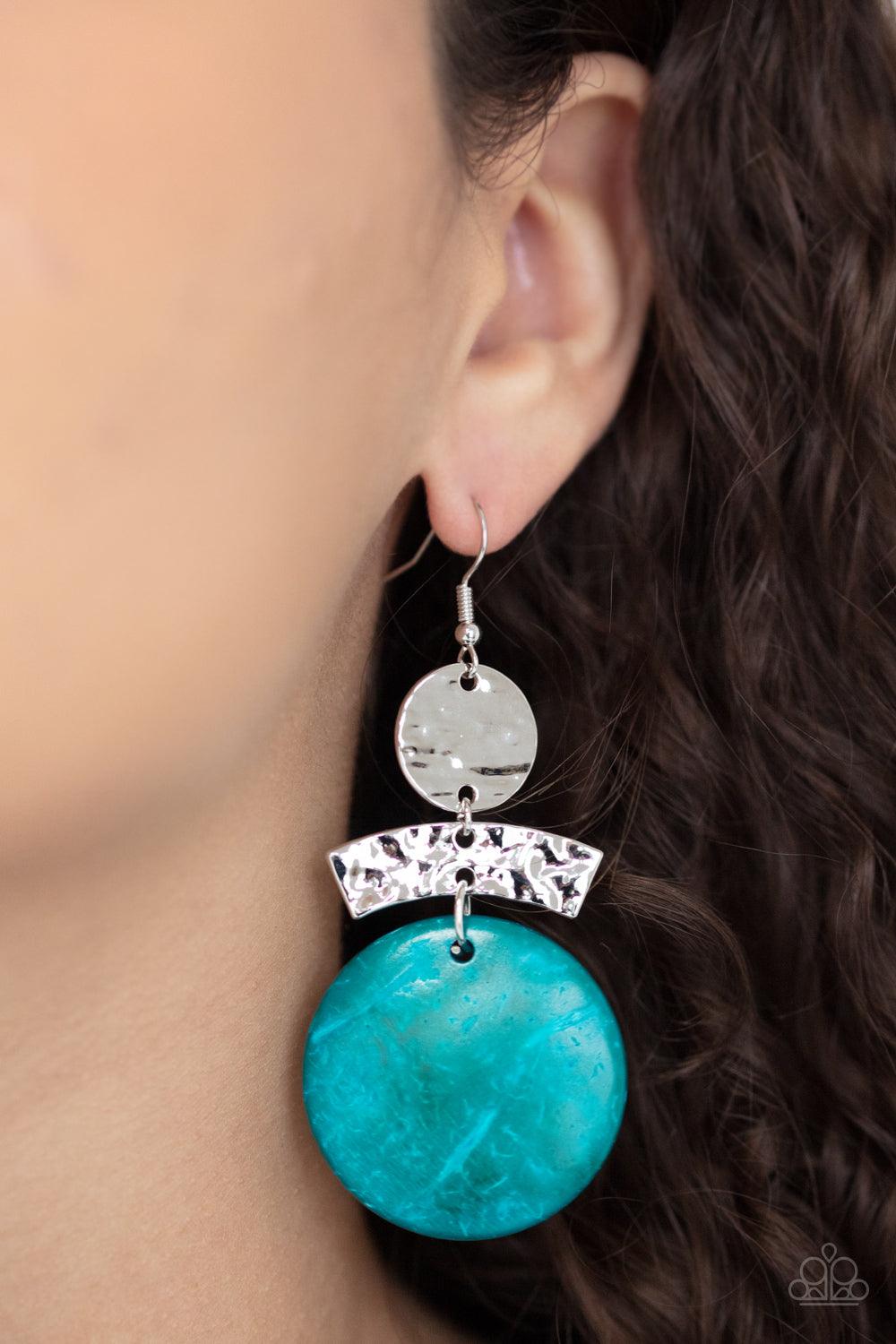 Paparazzi Accessories Diva Of My Domain - Blue Featuring a distressed blue finish, a wooden disc swings from the bottom of a hammered curved plate and hammered silver disc, coalescing into an earthy lure. Earring attaches to a standard fishhook fitting. S