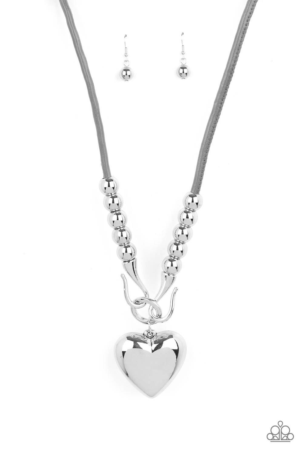 Paparazzi Accessories Forbidden Love - Silver Featuring chunky silver beads, an oversized silver heart pendant swings from dramatic silver hook-like fittings that attach to a bold gray leather cord draped across the chest for a haute heartbreaker look. Fe