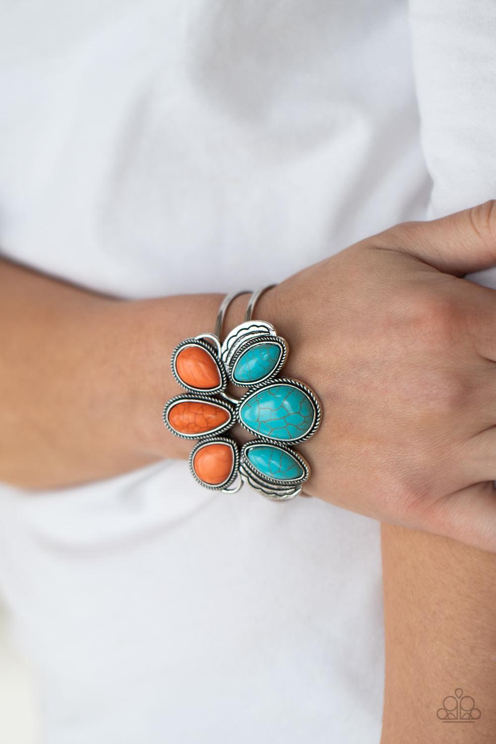 Paparazzi Accessories Botanical Badlands - Orange Encased in antiqued silver rope-like frames, a colorful collection of turquoise and orange stone teardrops stack into a rustic centerpiece atop a layered silver cuff. Features an adjustable hinged closure.