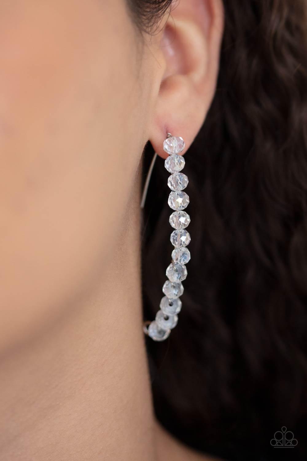 Paparazzi Accessories GLOW Hanging Fruit - White A glittery collection of iridescent white rhinestones are fitted in place along a curved silver wire, creating a glamorous hanging post. Earring attaches to a standard hanging post fitting. Sold as one pair