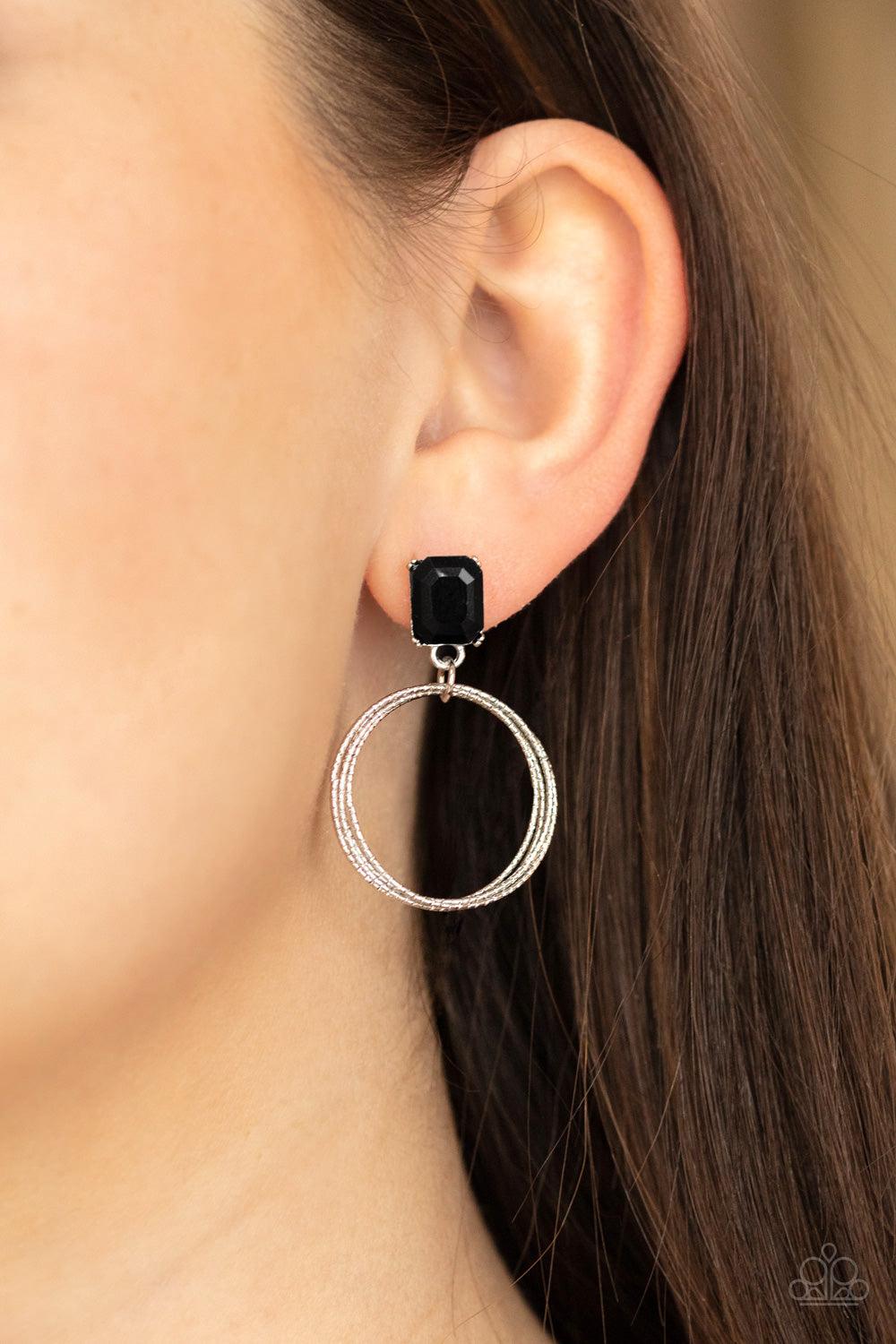 Paparazzi Accessories Prismatic Perfection - Black Encased in a pronged silver setting, a black emerald cut rhinestone links with a trio of textured silver rings, creating a romantic lure. Earring attaches to a standard post fitting. Sold as one pair of p