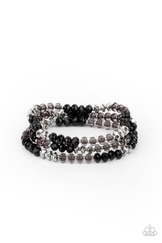 Paparazzi Accessories Stellar Strut - Black Infused with faceted silver beads, a glamorous collection of sparkly black crystals and smoky beads are threaded along stretchy bands around the wrist, creating glittery layers. Sold as one set of three bracelet