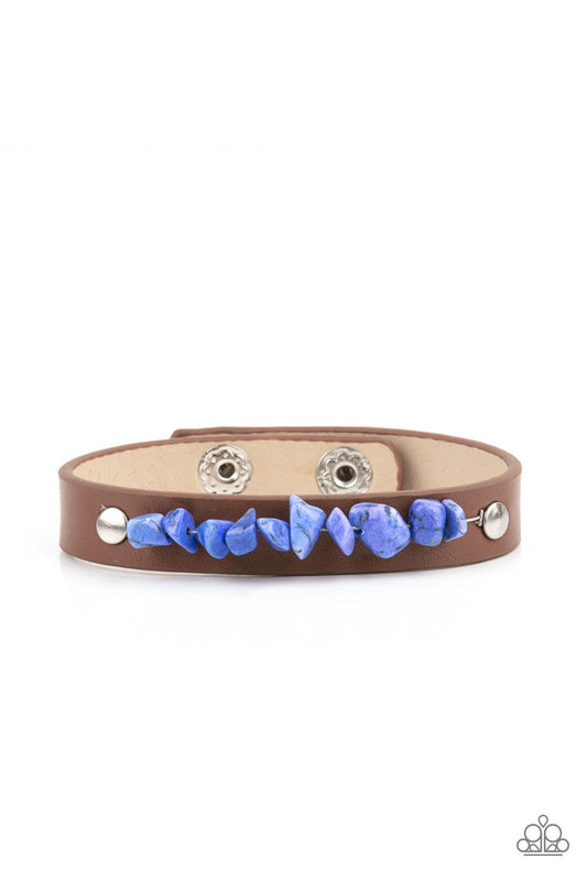 Paparazzi Accessories Pebble Paradise - Blue A strand of blue pebbles is studded in place across the front of a skinny brown leather band, creating a colorful earthy display around the wrist. Features an adjustable snap closure. Sold as one individual bra