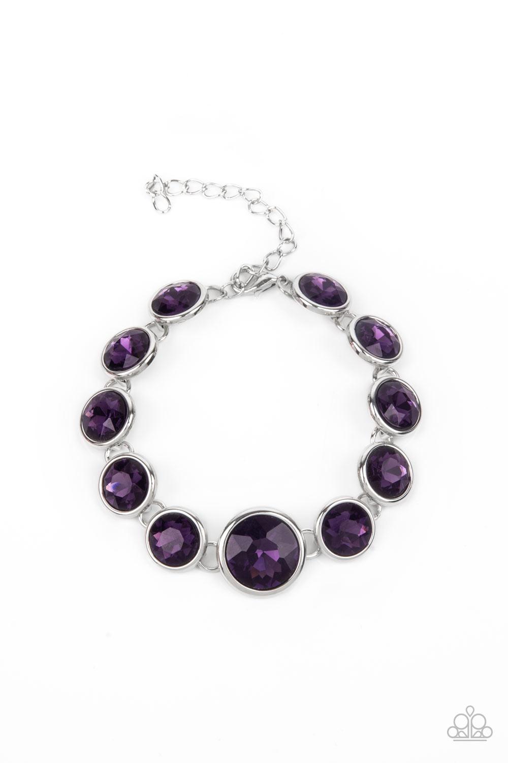 Paparazzi Accessories Lustrous Luminosity - Purple Featuring sleek silver fittings, an oversized collection of sparkly purple gems delicately link around the wrist. The centermost gem is slightly larger than the rest, adding a glamorous finish. Features a