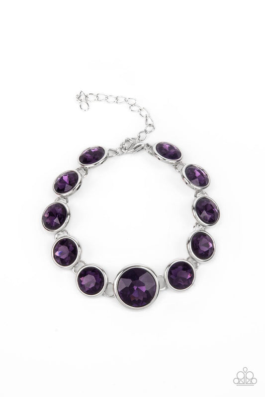 Paparazzi Accessories Lustrous Luminosity - Purple Featuring sleek silver fittings, an oversized collection of sparkly purple gems delicately link around the wrist. The centermost gem is slightly larger than the rest, adding a glamorous finish. Features a