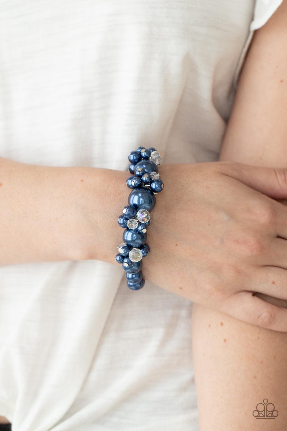 Paparazzi Accessories Upcycled Upscale - Blue Dainty blue pearls and sparkly white crystal-like beads cluster between oversized blue pearls that are threaded along stretchy bands around the wrist, creating a stunning centerpiece. Sold as one individual br