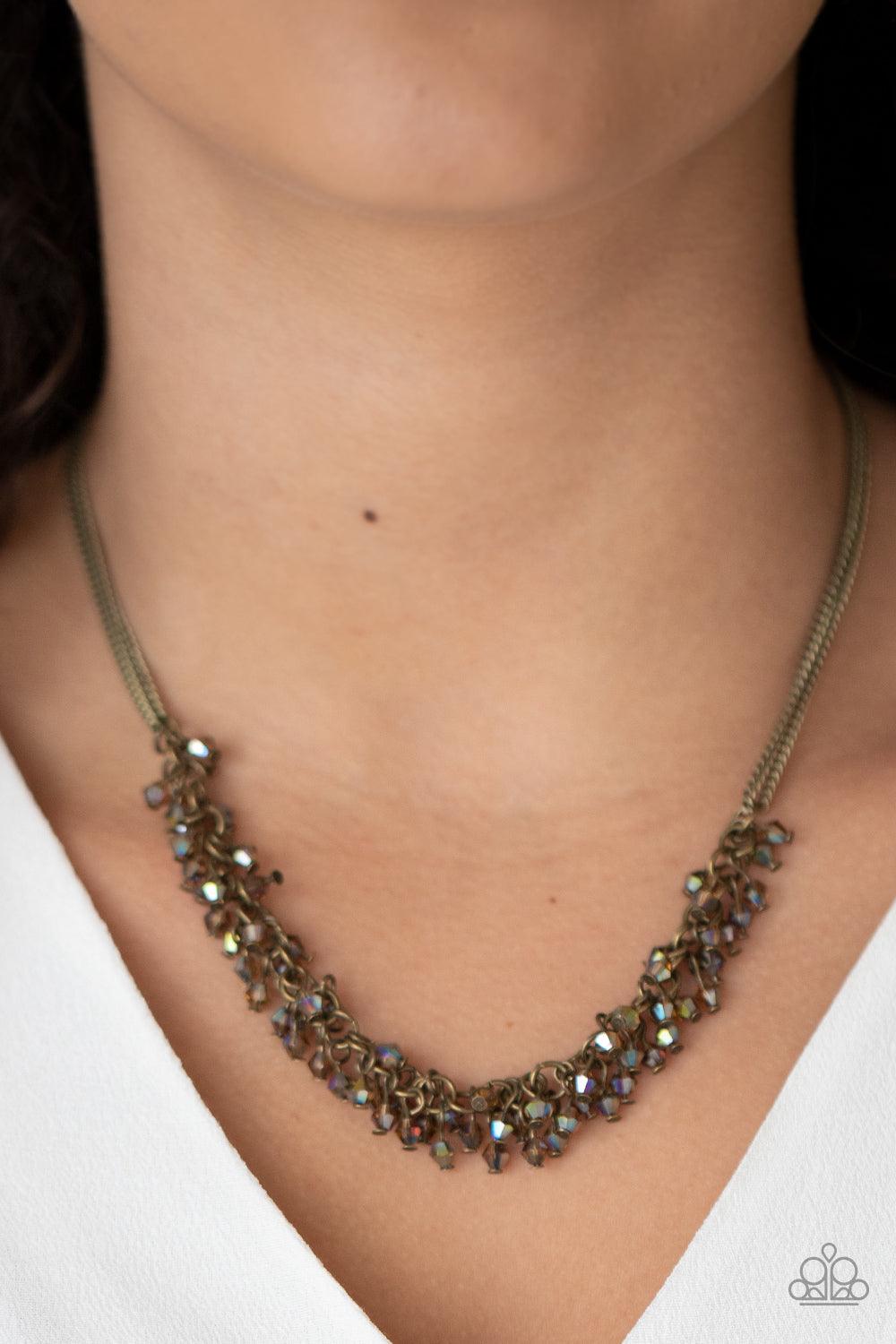 Paparazzi Accessories Let There Be TWILIGHT - Brass Dainty brassy tone-on-tone iridescent beads swing from doubled brass chains, creating a clustered fringe below the collar. Features an adjustable clasp closure. Sold as one individual necklace. Includes